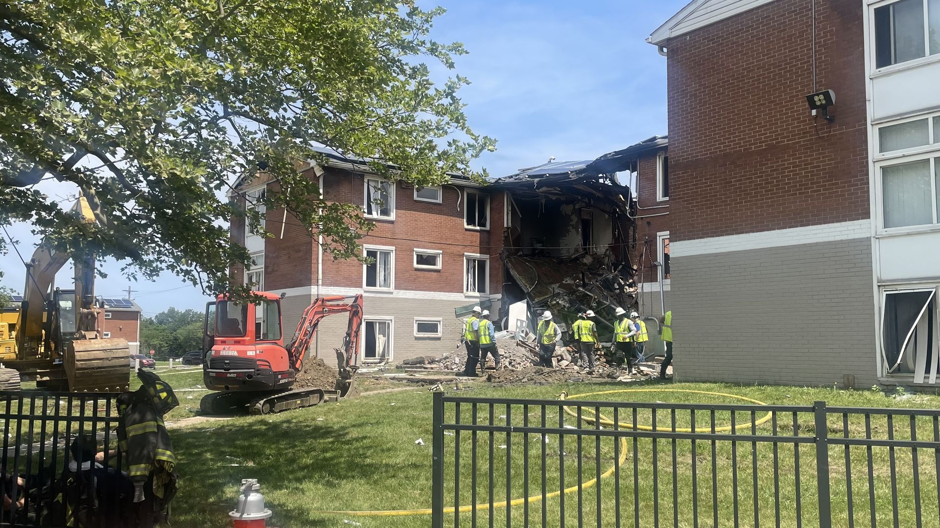An apartment complex after a fire, with crews working 