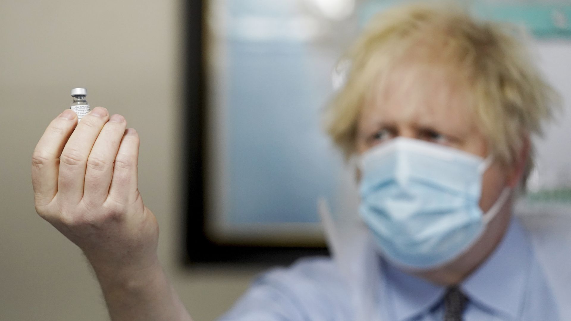Prime Minister Boris Johnson holds a bottle of the Pfizer BioNTech vaccine as he visits a COVID-19 vaccination centre in Batley, on February 1, 2021 in West Yorkshire, England