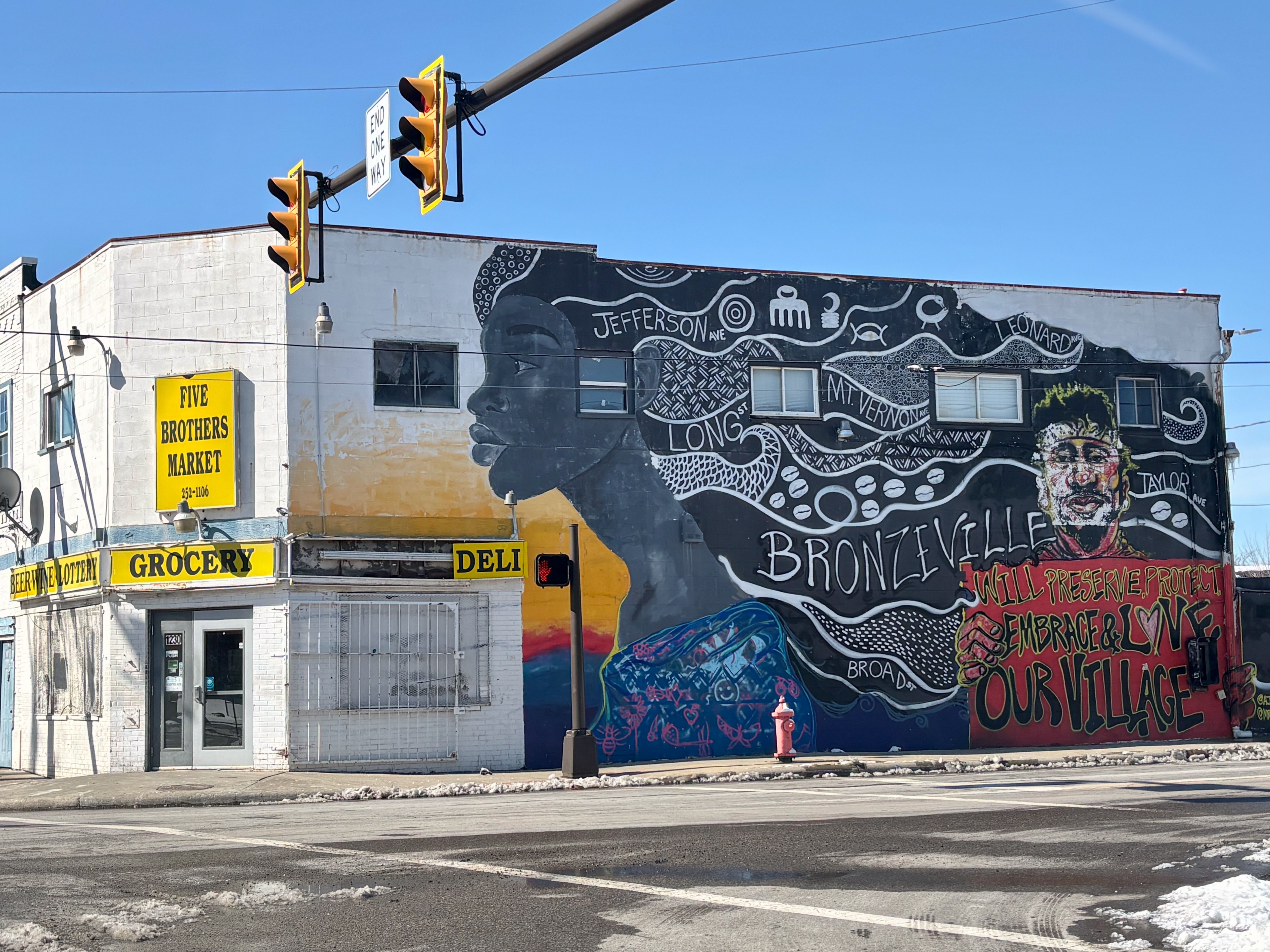 A mural that reads "Bronzeville will preserve, protect, embrace and love our village" with a portrait of a Black woman and the neighborhood's streets in her hair