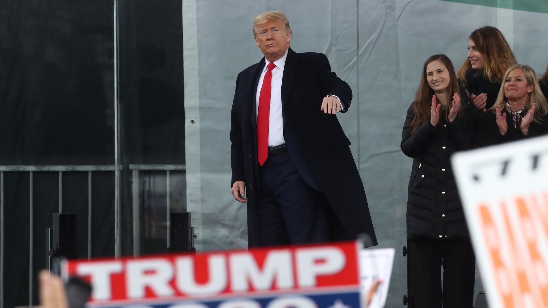 Trump stands in front of a crowd.