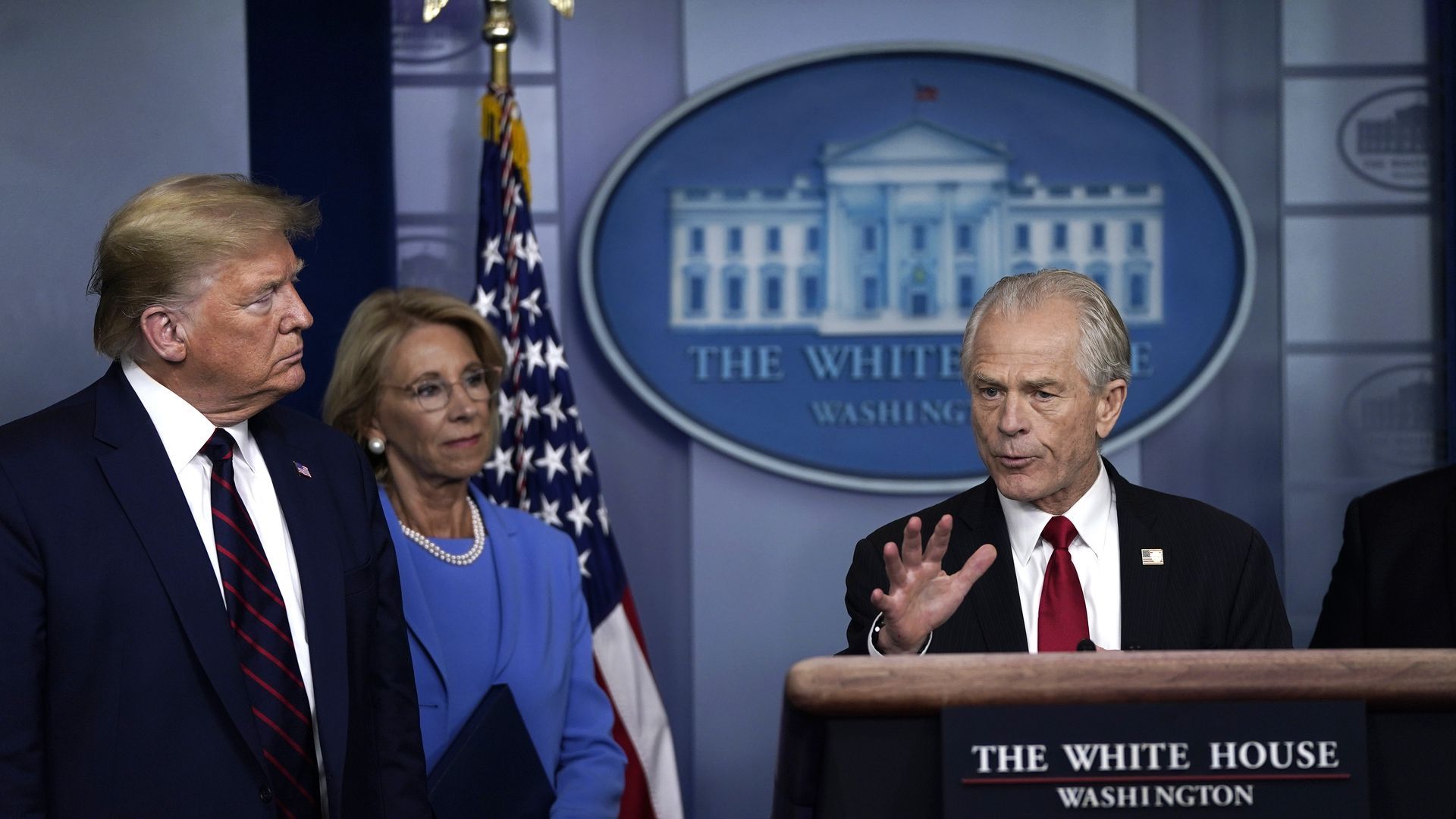 Peter Navarro speaks at the White House press room as President Trump and Sec. of Education Betsy DeVos stand to the side