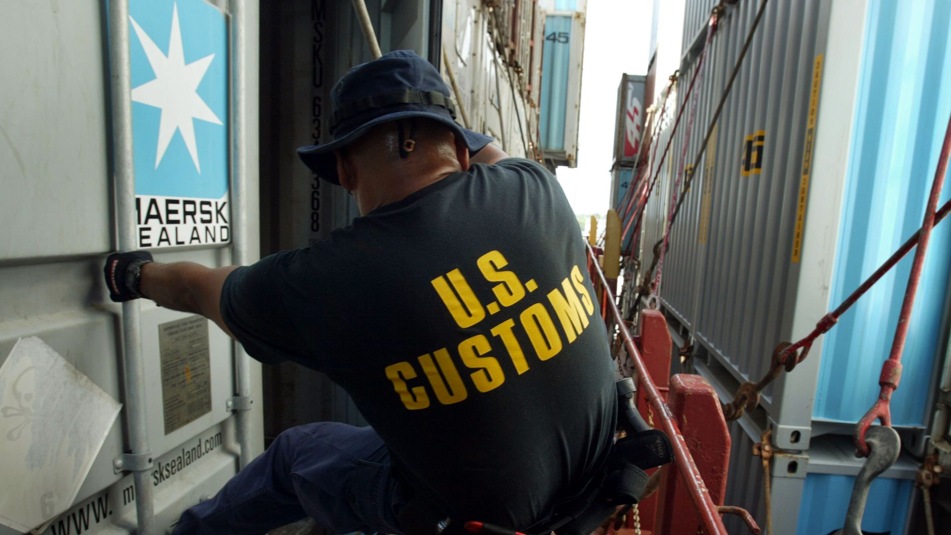 A Customs official inspects a shipping container.