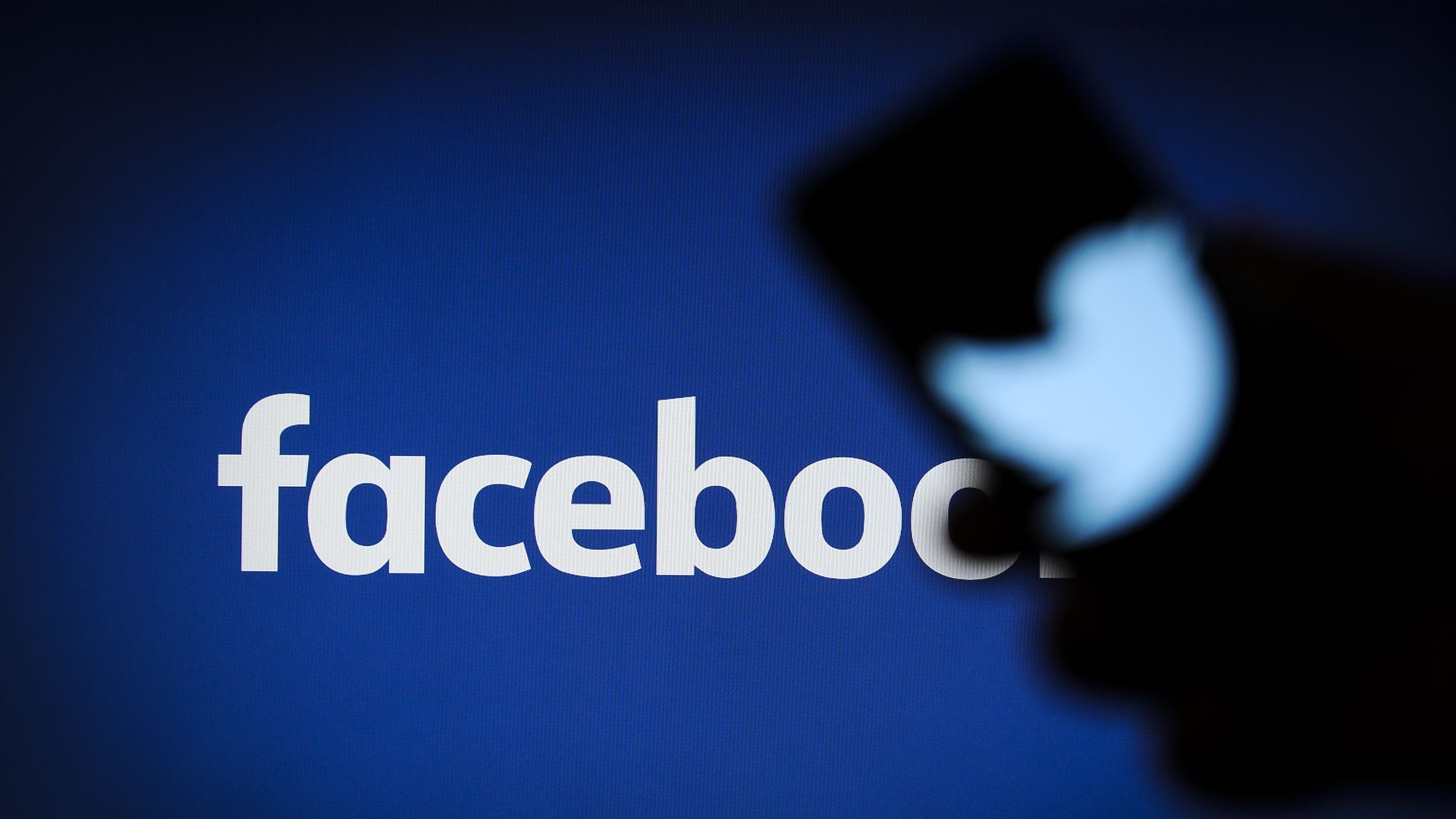 A Twitter logo is seen on a portable device in this photo illustration