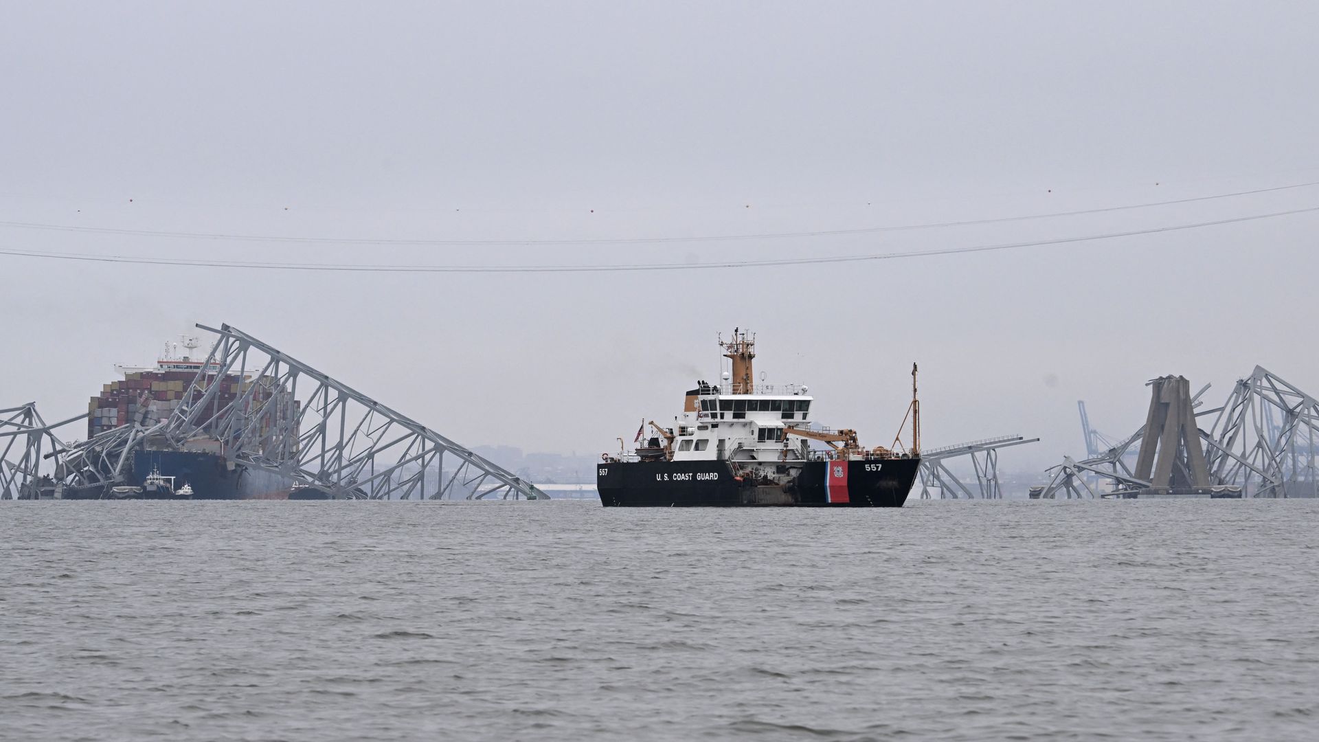 A faraway shot of the collapsed bridge in Baltimore, in grey skies