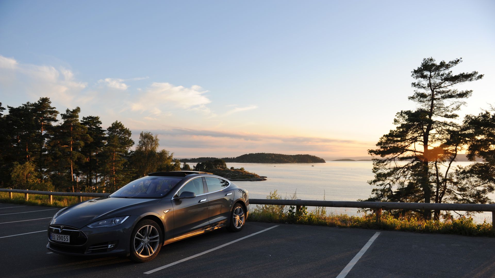 Photo of Tesla parked near beautiful vista of Norway