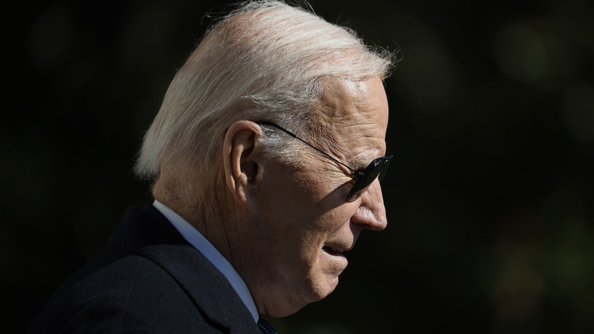 President Biden, wearing sunglasses, is shown in profile.