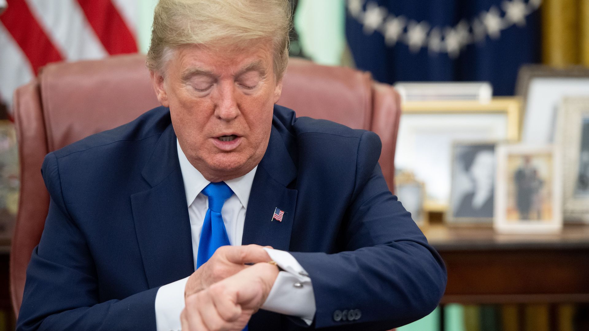 President Trump checks his wristwatch while speaking in the Oval Office.