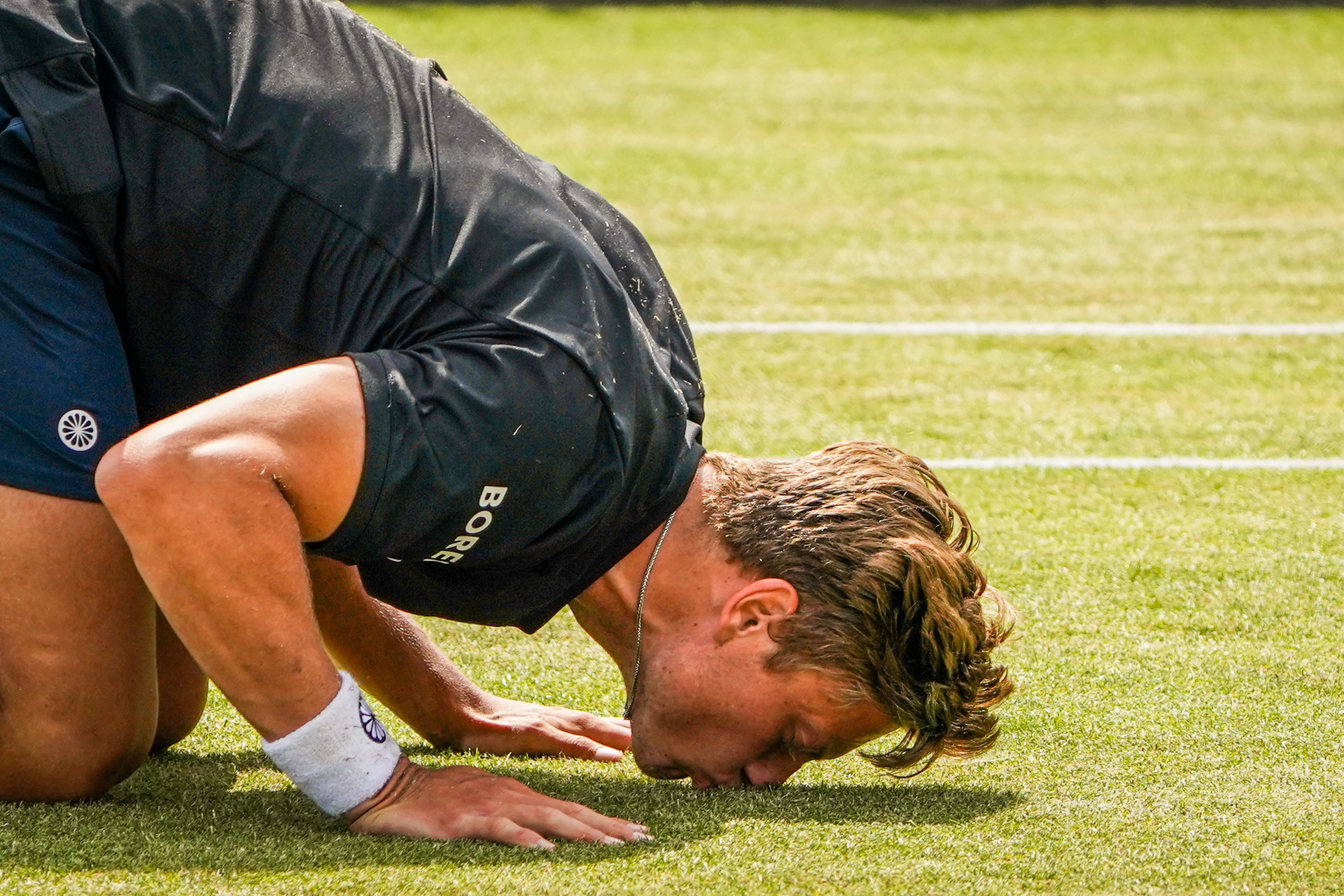 Tennis player kissing grass
