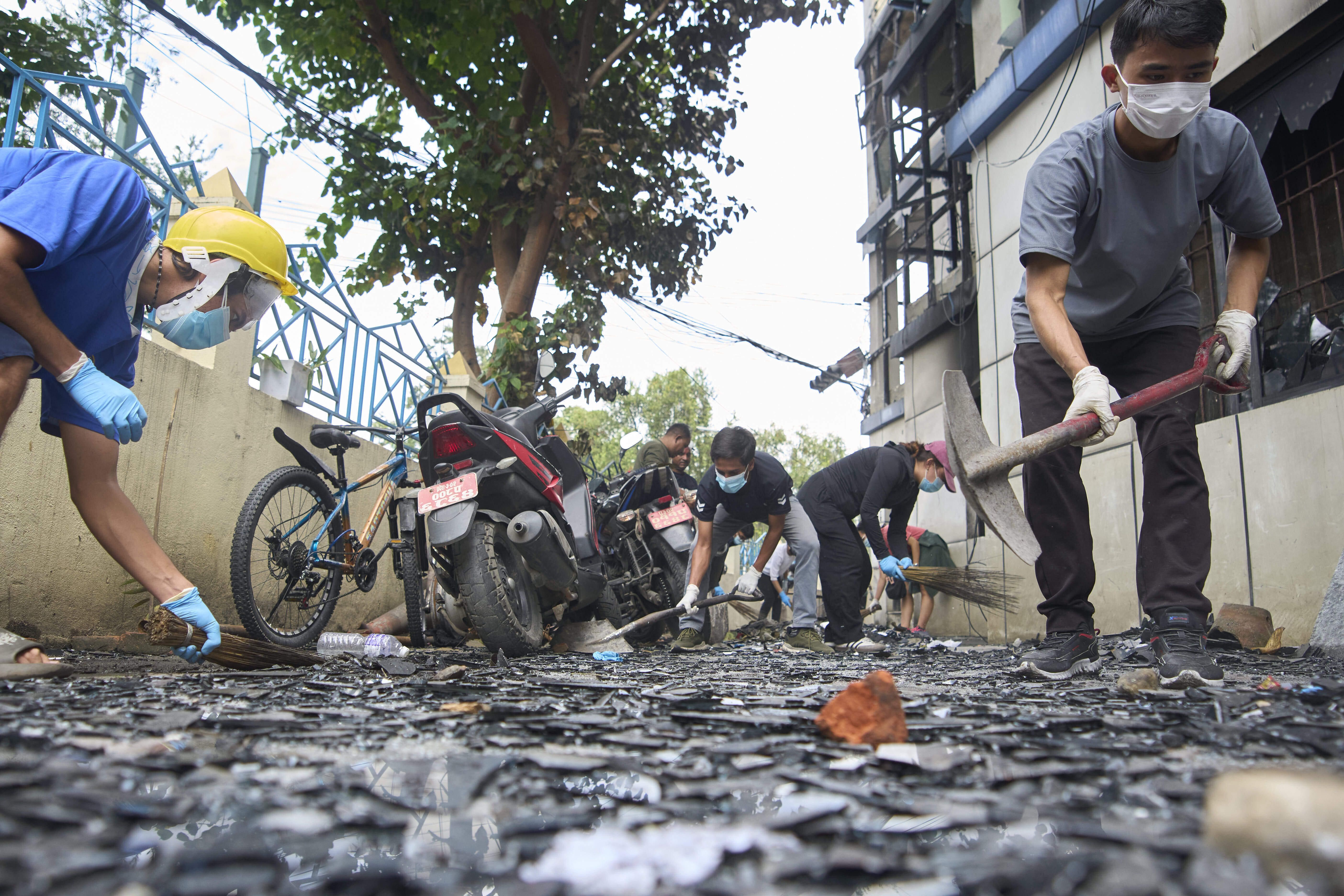 People clean debris in Kathmandu