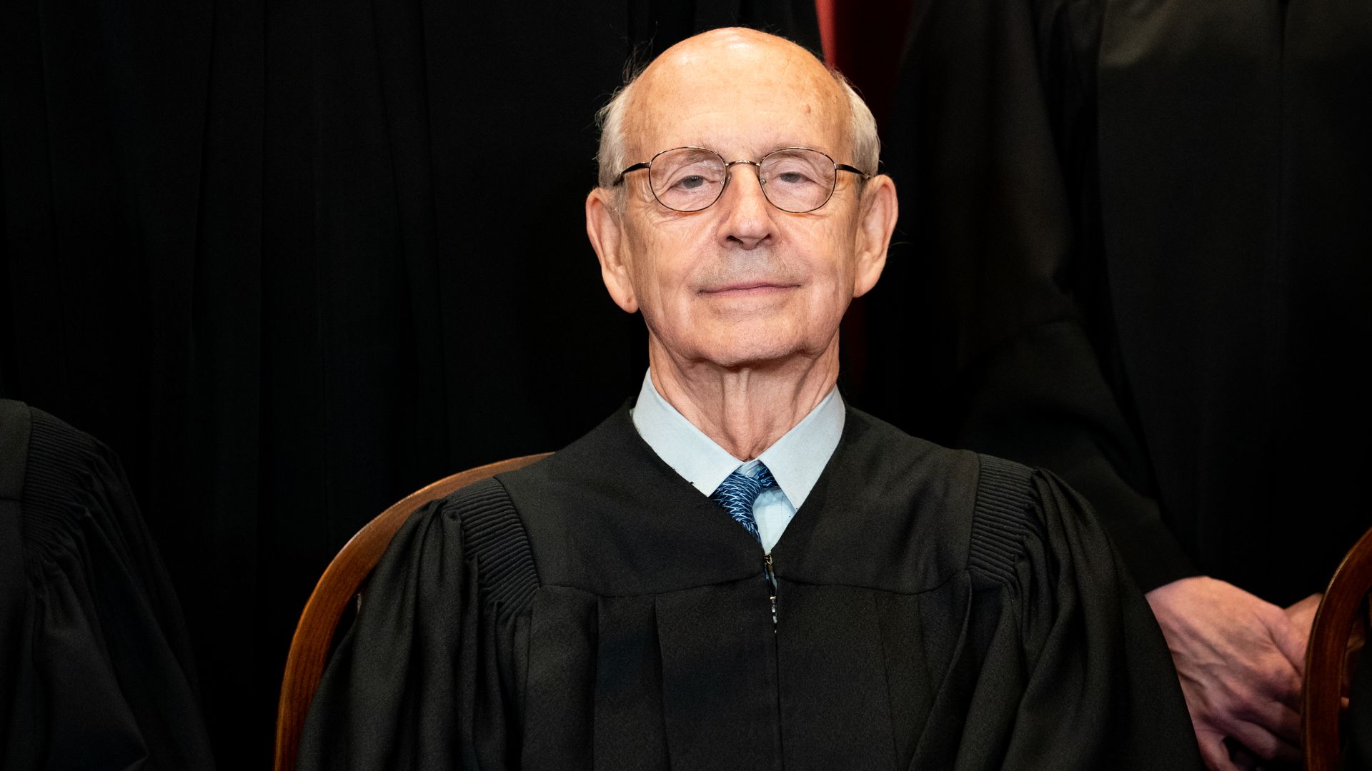 A close-up of Supreme Court Justice Stephen Breyer in black robe posing as part of a formal group photo