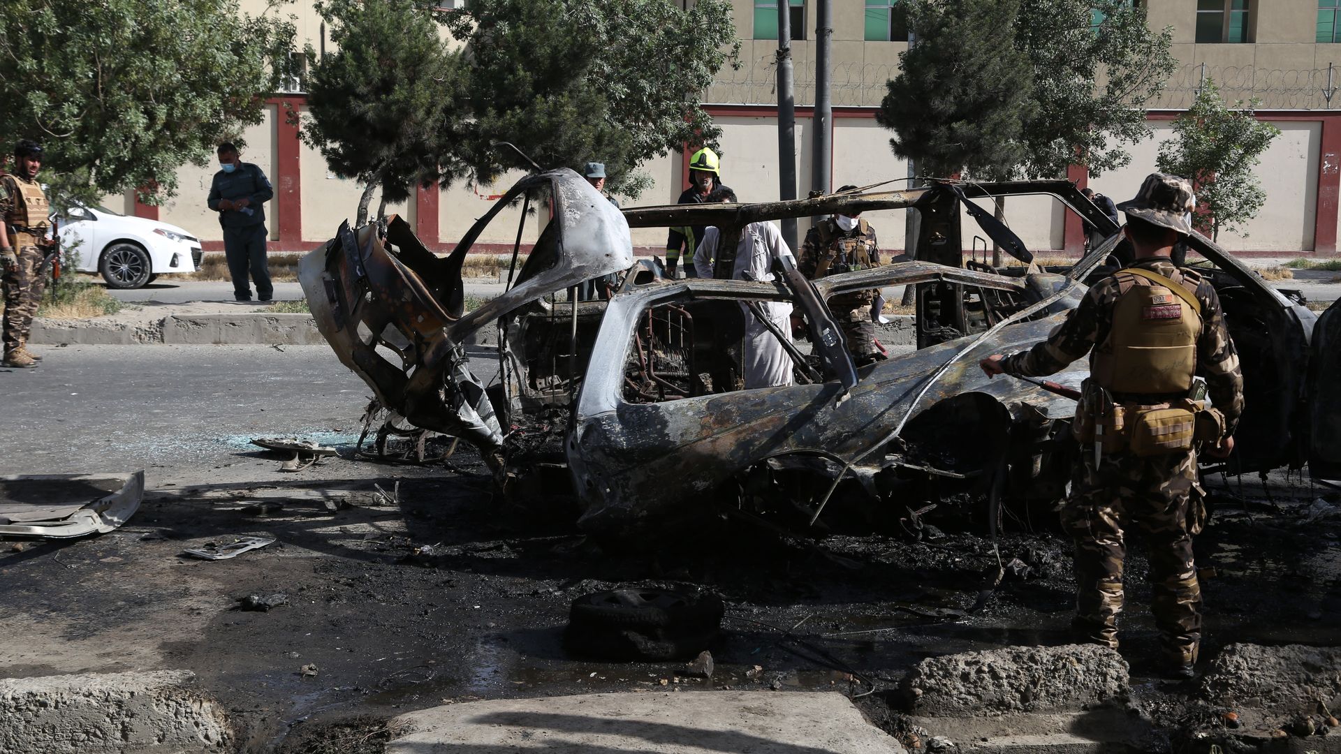 Afghan security force members inspect the site of an explosion in Kabul.