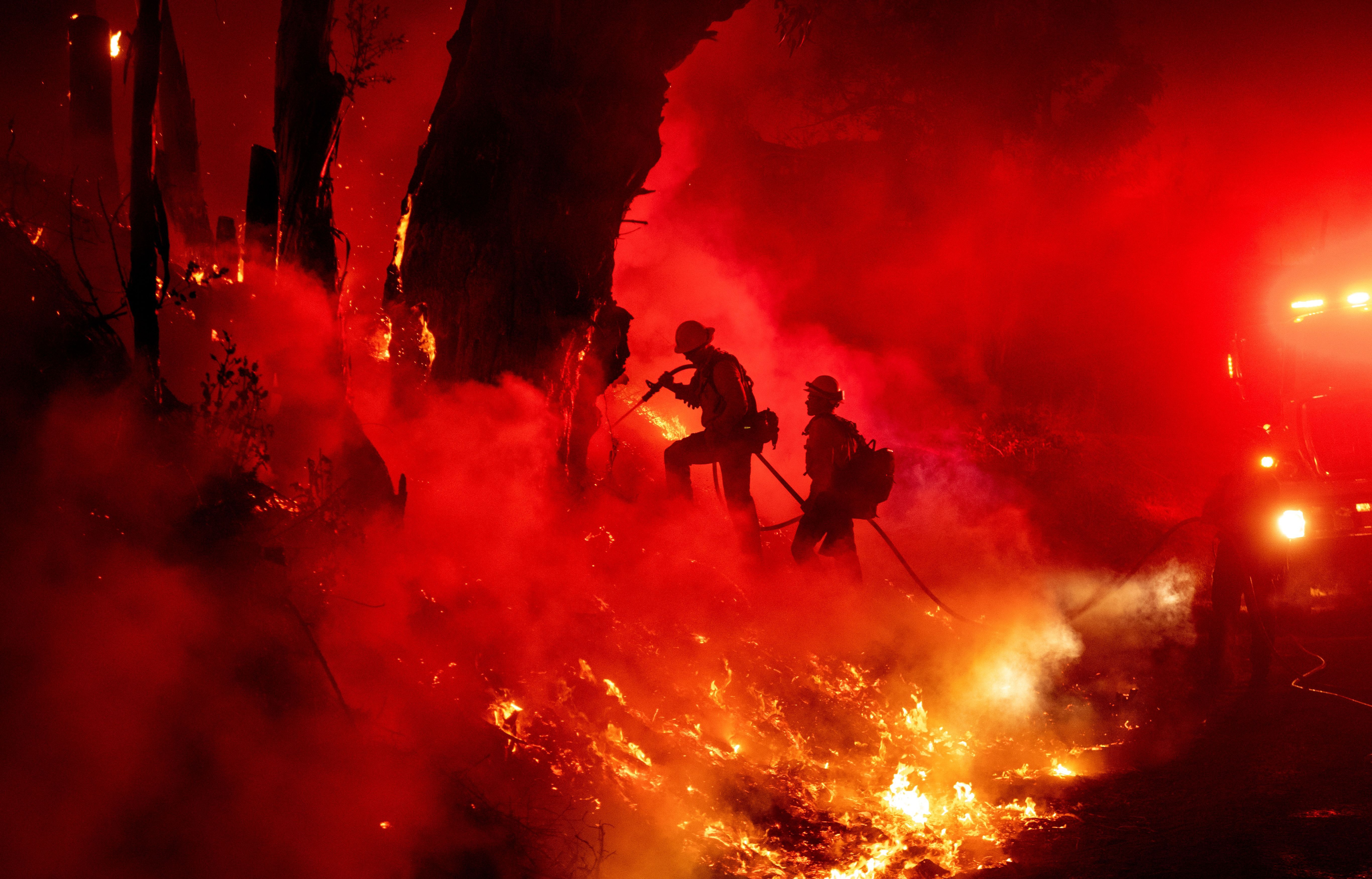 Firefighters work to control flames from a backfire during the Maria fire in Santa Paula, California 