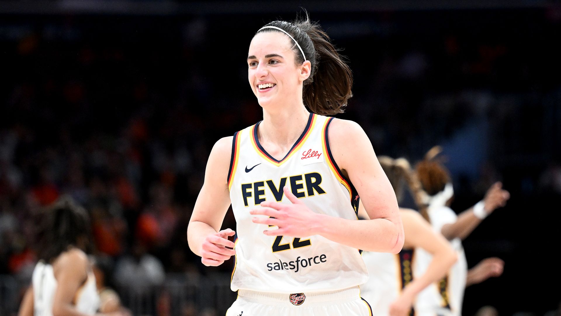 Caitlin Clark wearing her Fever jersey and smiling