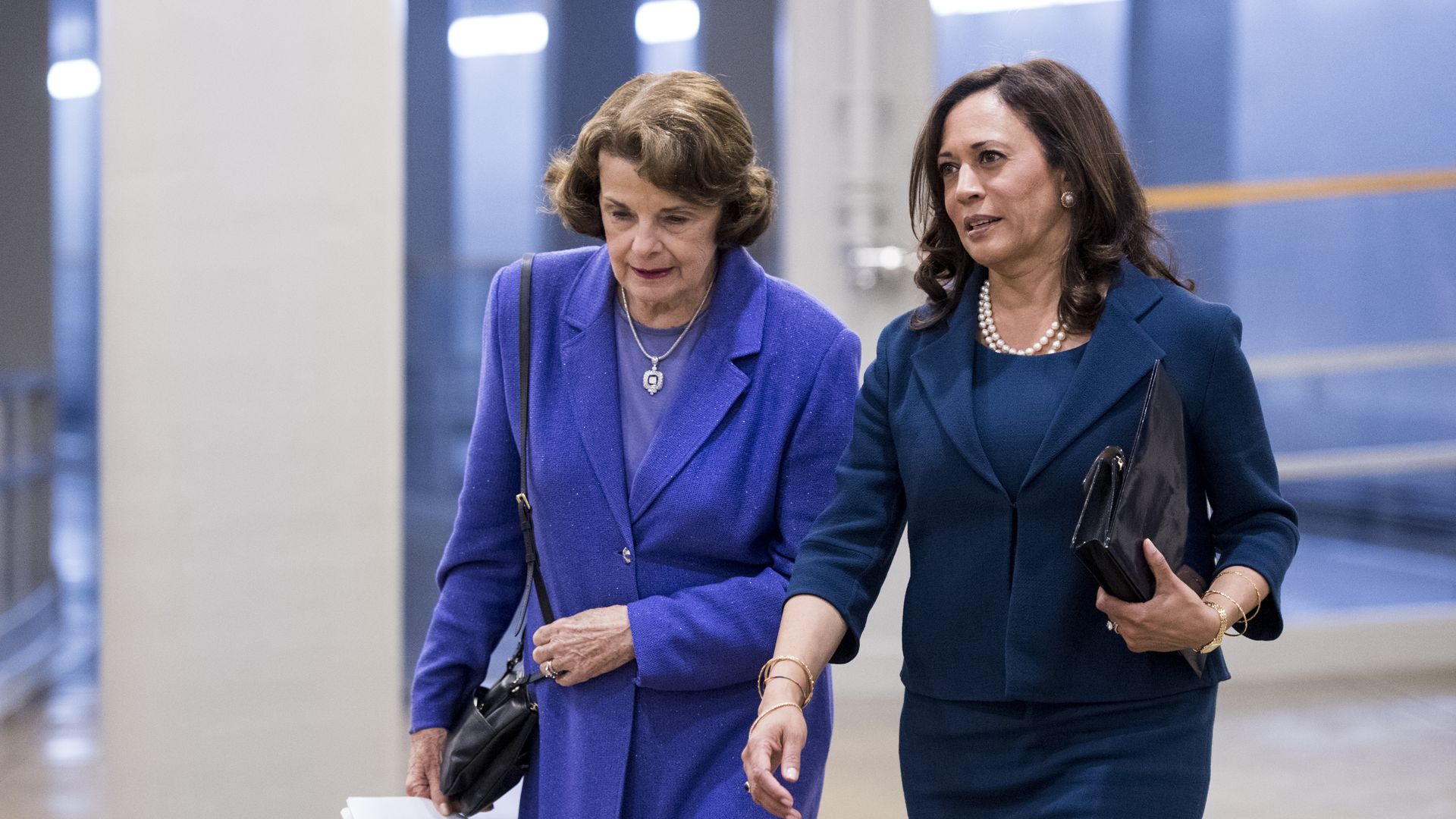 Senators Dianne Feinstein and Kamala Harris walking side by side in the Capitol building 