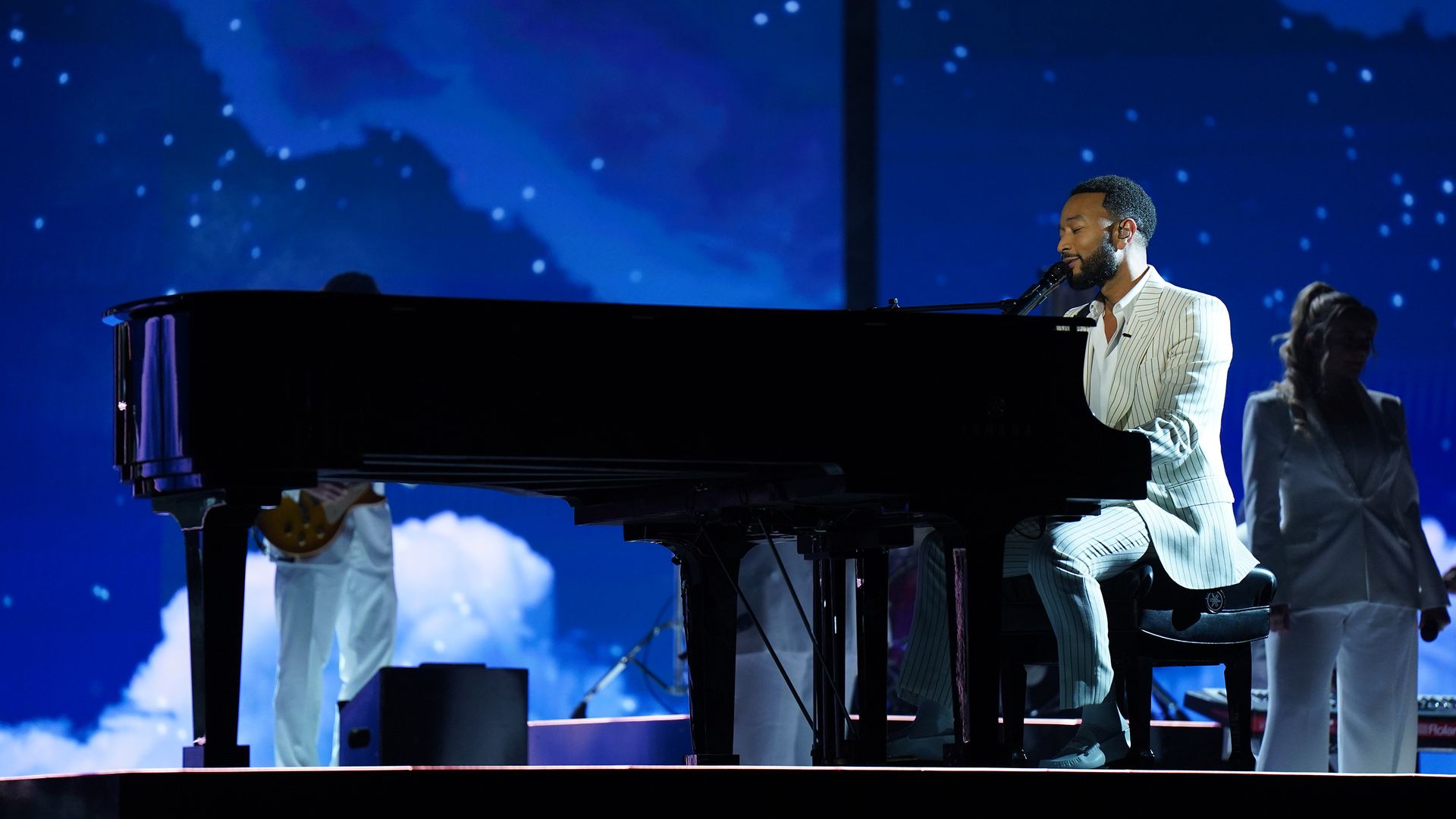 A photo of John Legend playing a grand piano