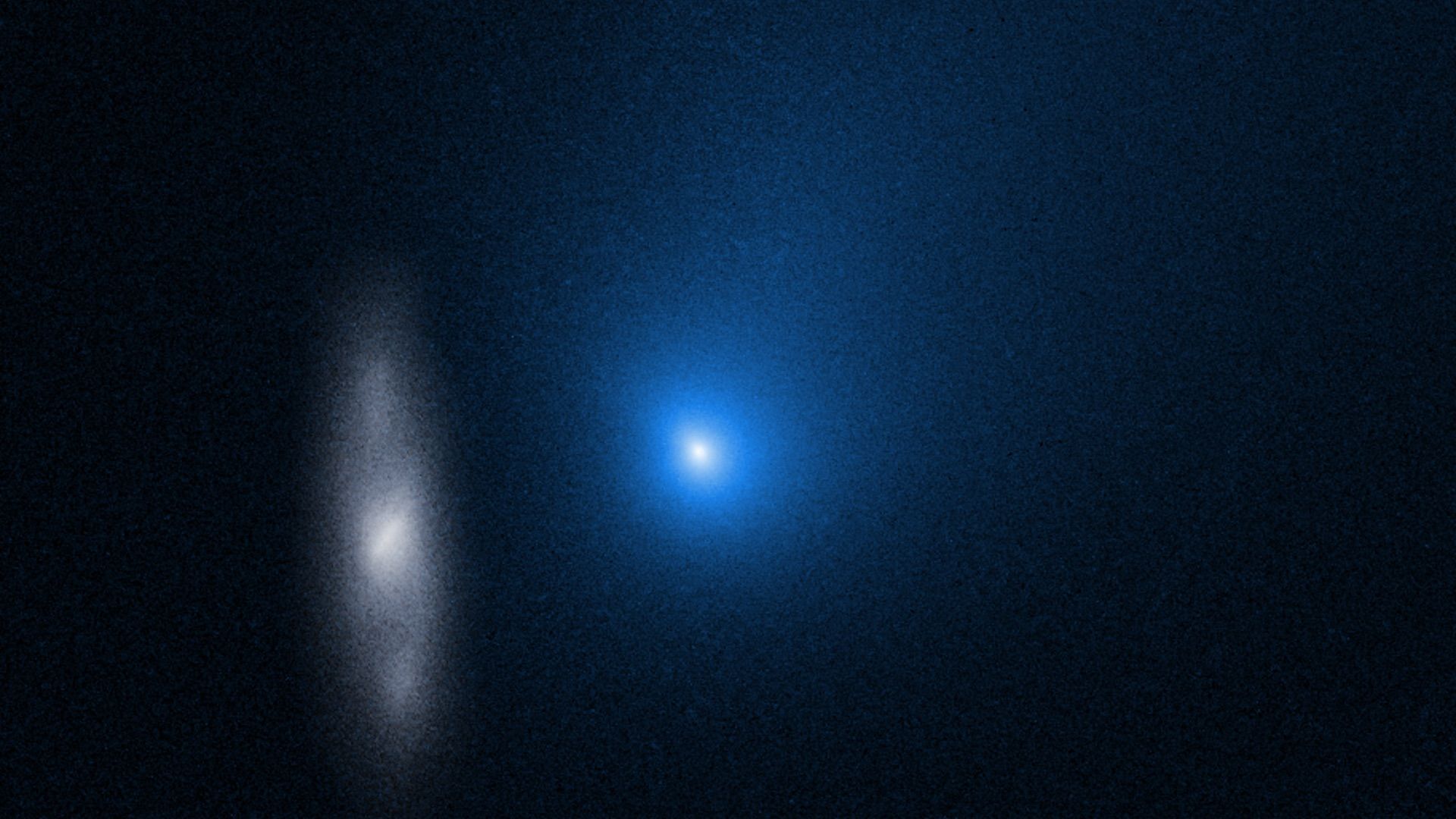 A comet in blue and a stretched out distorted galaxy seen in the foreground