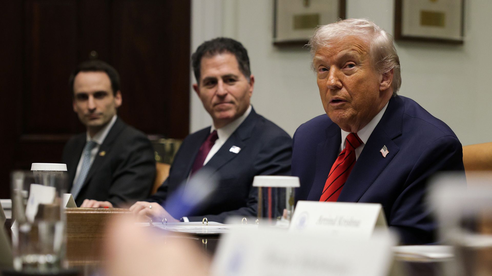 Three men sitting at a board table