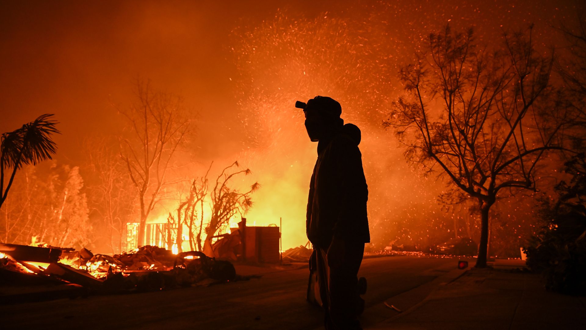 A house in on fire as residents try to escape the site in Pacific Palisades, California, Los Angeles, United States on January 8, 2025. A fast-moving wildfire has forced 30,000 people to evacuate, with officials warning that worsening winds could further escalate the blaze.