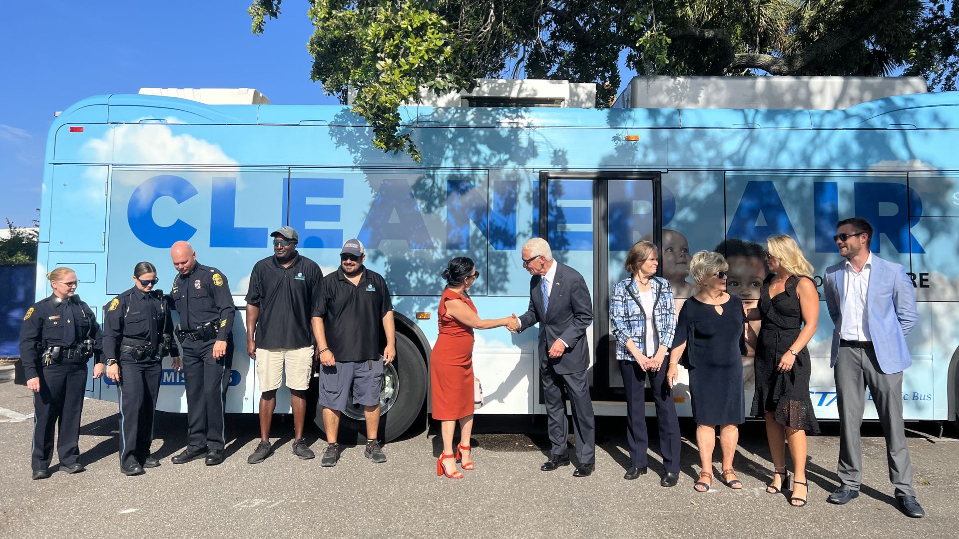 Crust shakes hands with constituents in front of the electric bus
