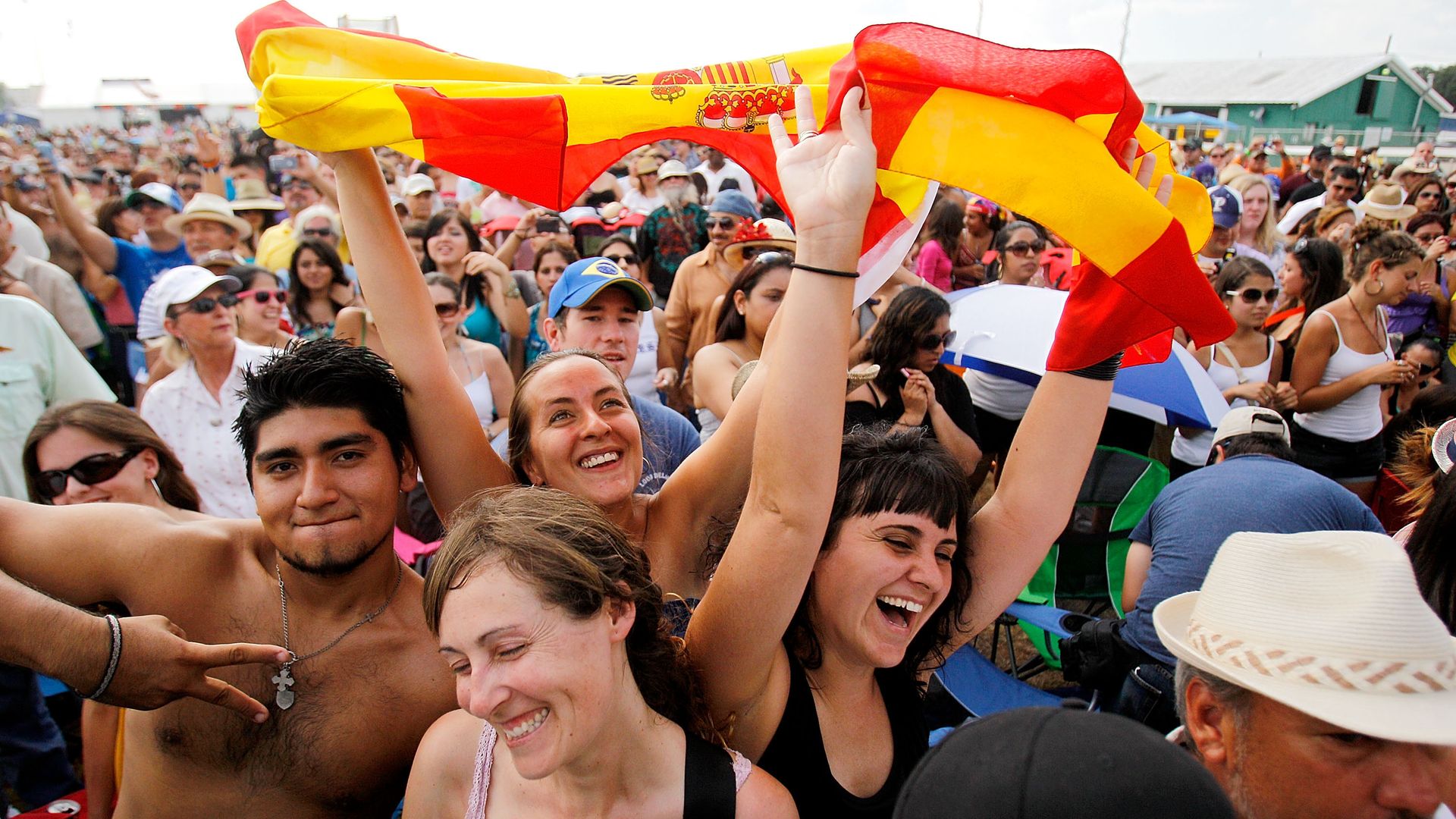 Photo shows a picture of the crowd at Jazz Fest waving a flag.
