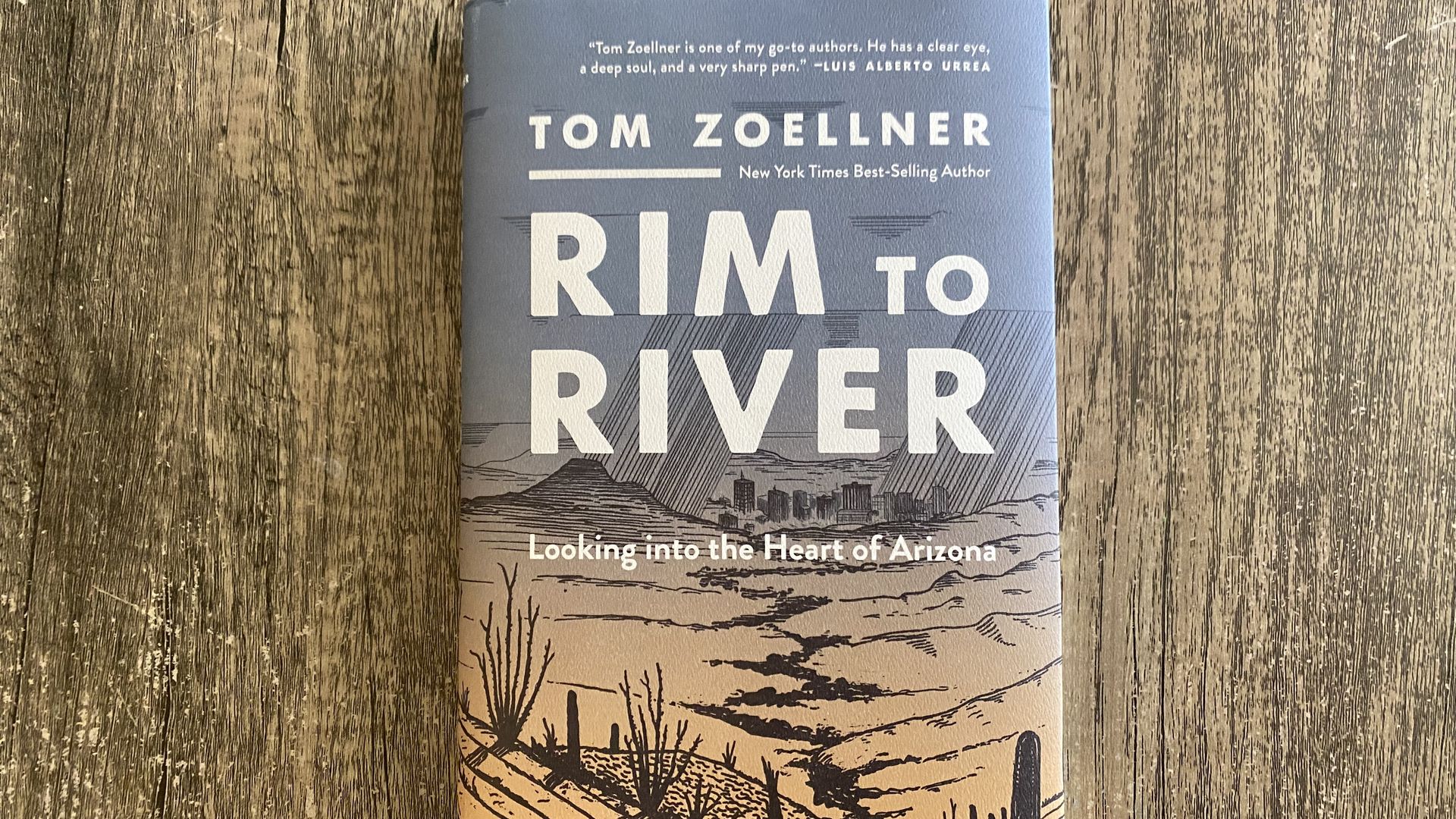 A book titled Rim to River on a light colored wood grained tabled. 