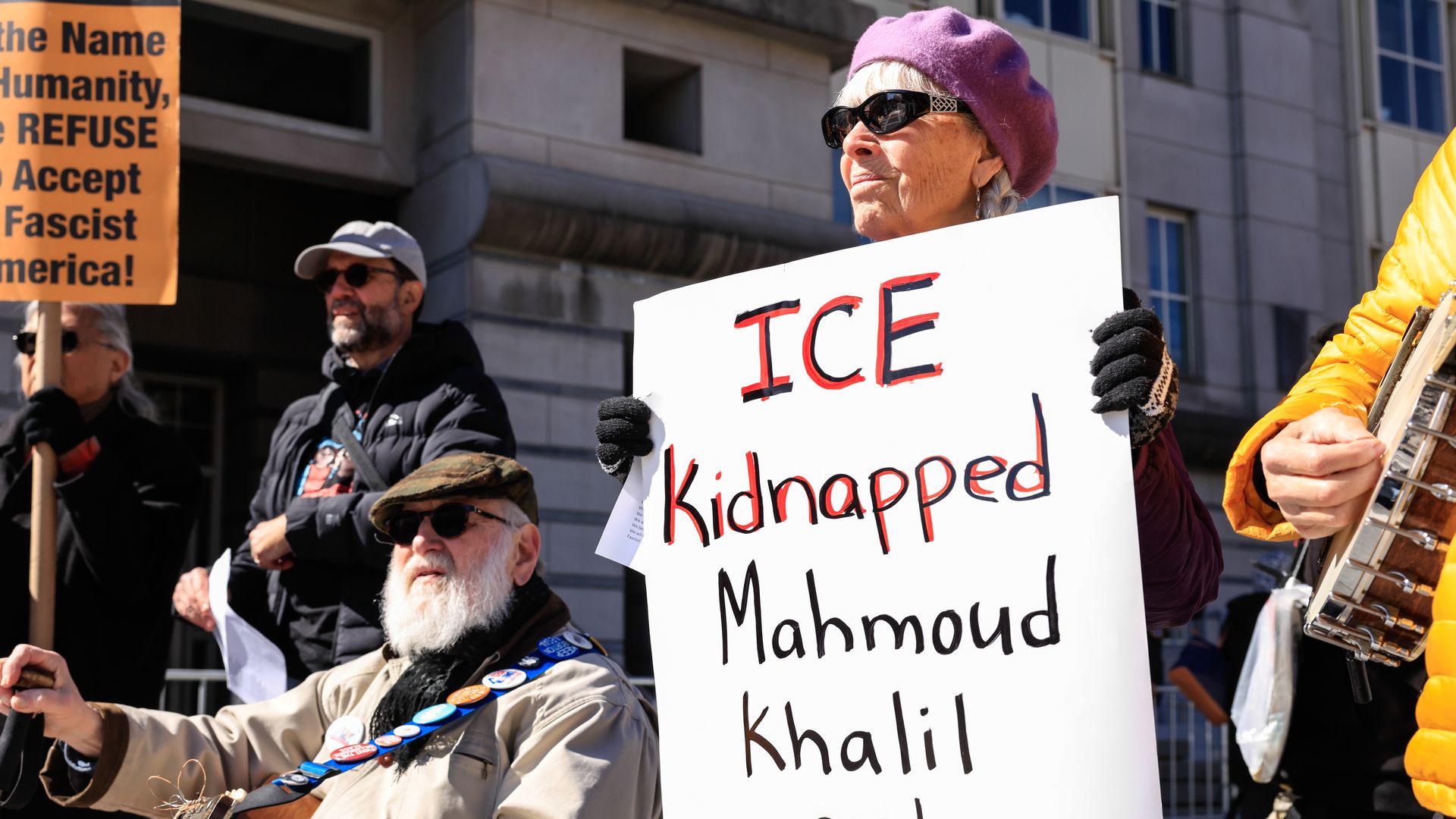 A woman holds a sign at a protest that reads "ICE Kidnapped Mahmoud Khalil and many others."