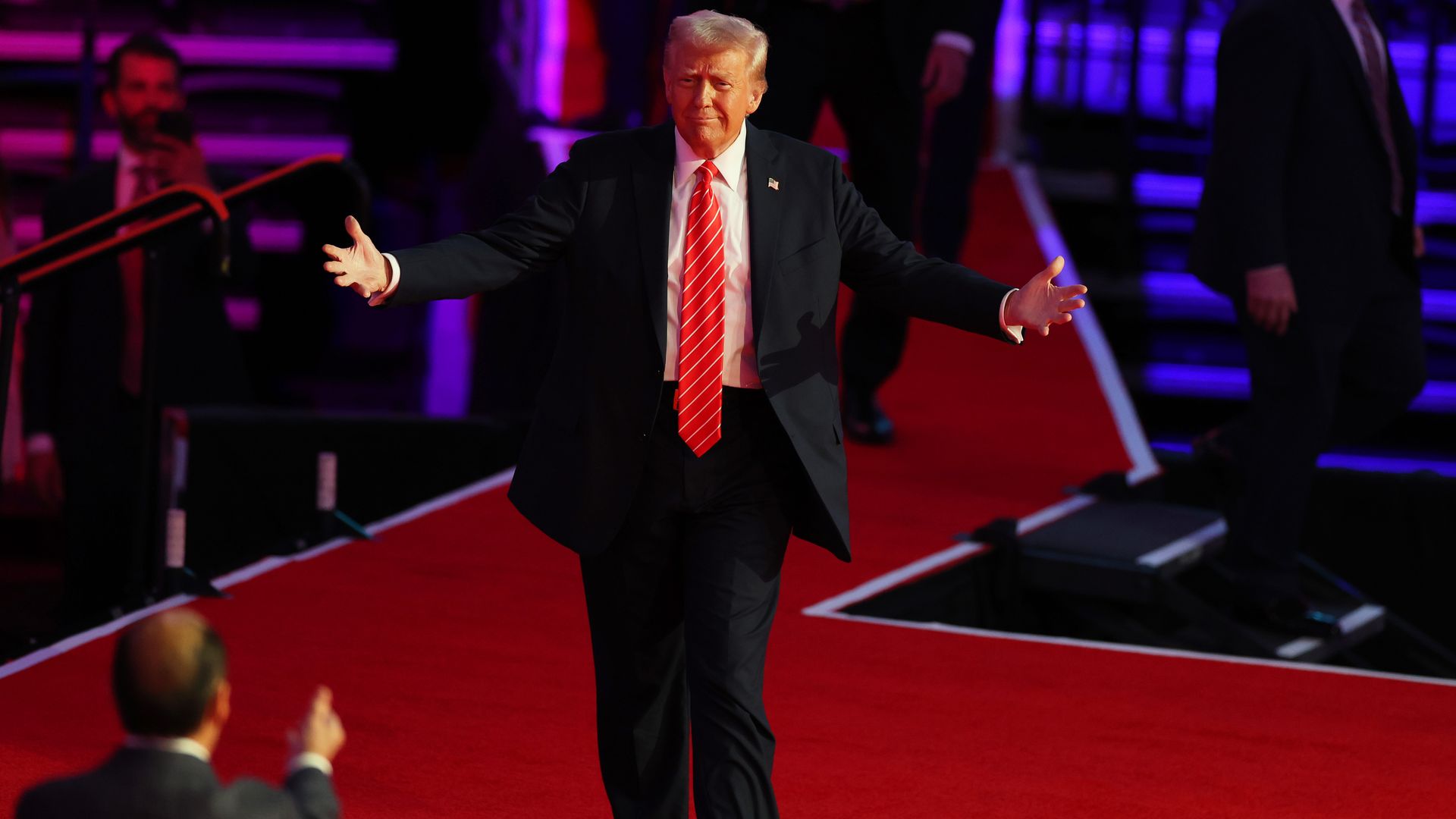 Donald Trump gestures with open arms at a pre-inauguration rally.