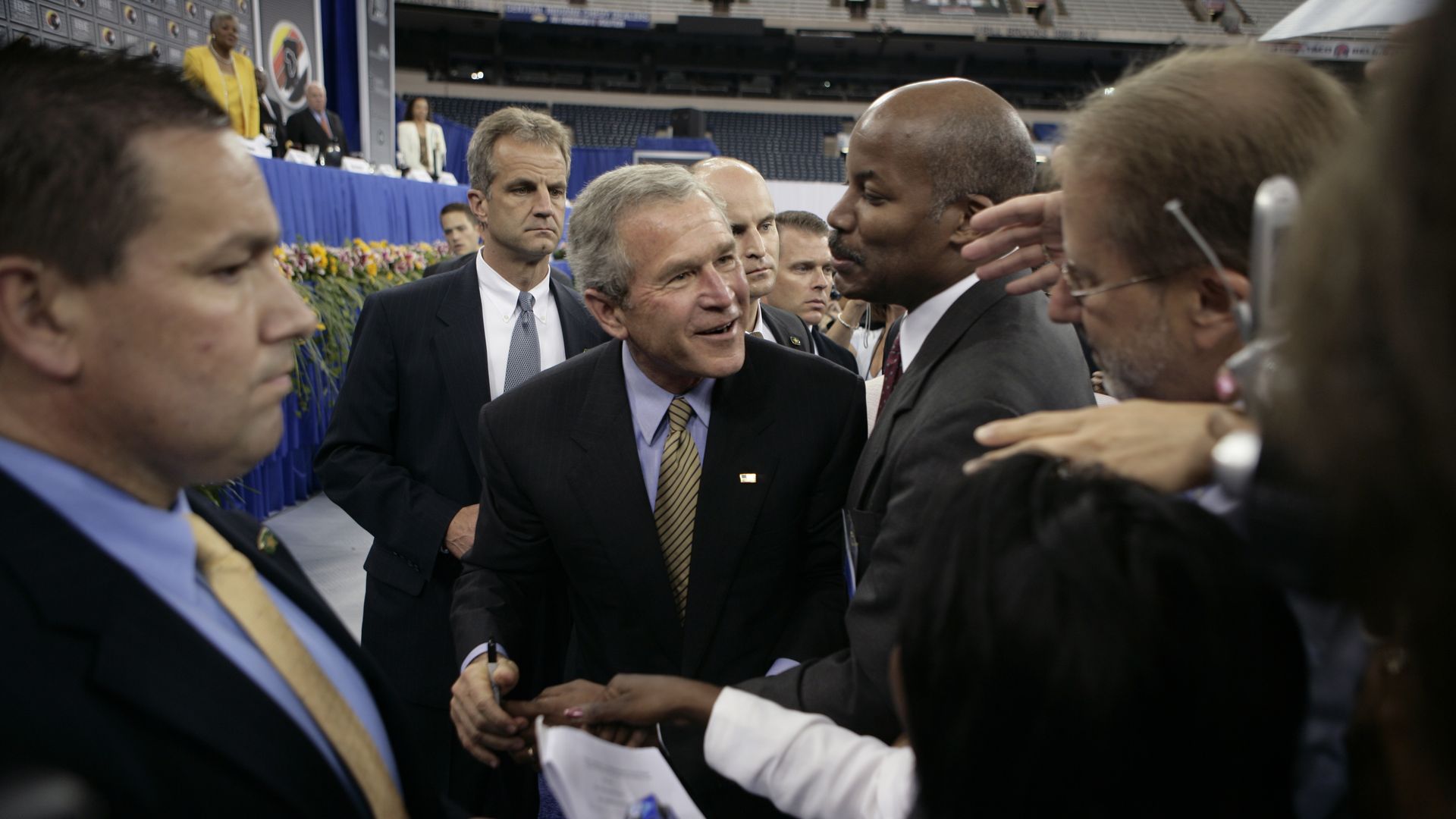 President George W. Bush is surrounded by people.
