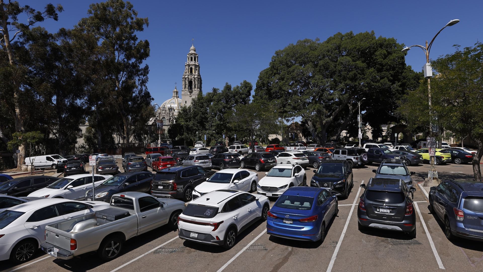 Dozens of vehicles fill a parking lot in Balboa Park. 