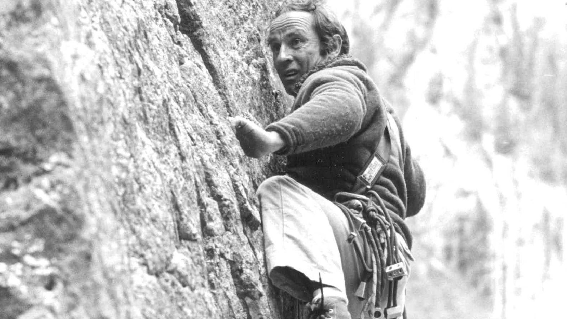 Yvon Chouinard rock climbs in a black and white photo