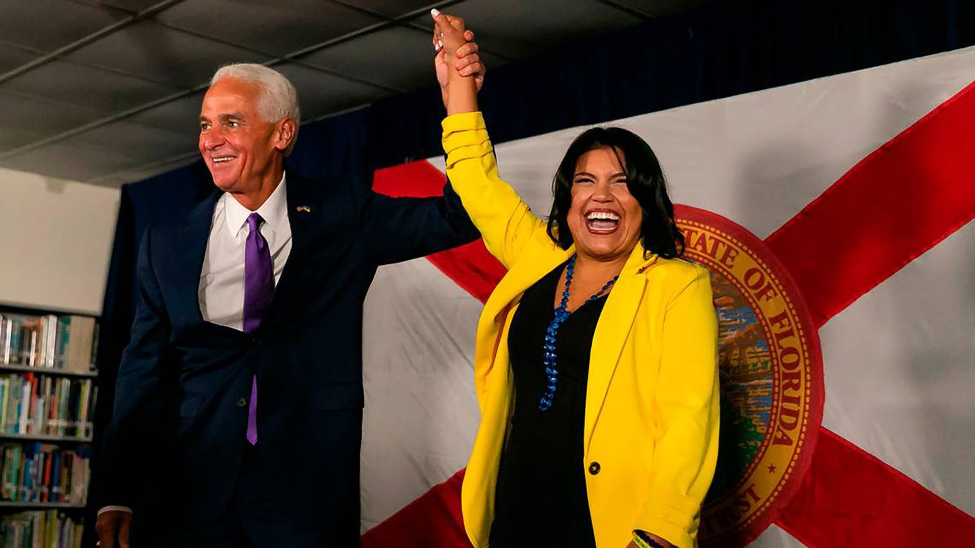 Charlie Crist holds Karla Hernandez-Mats' hand in the air.