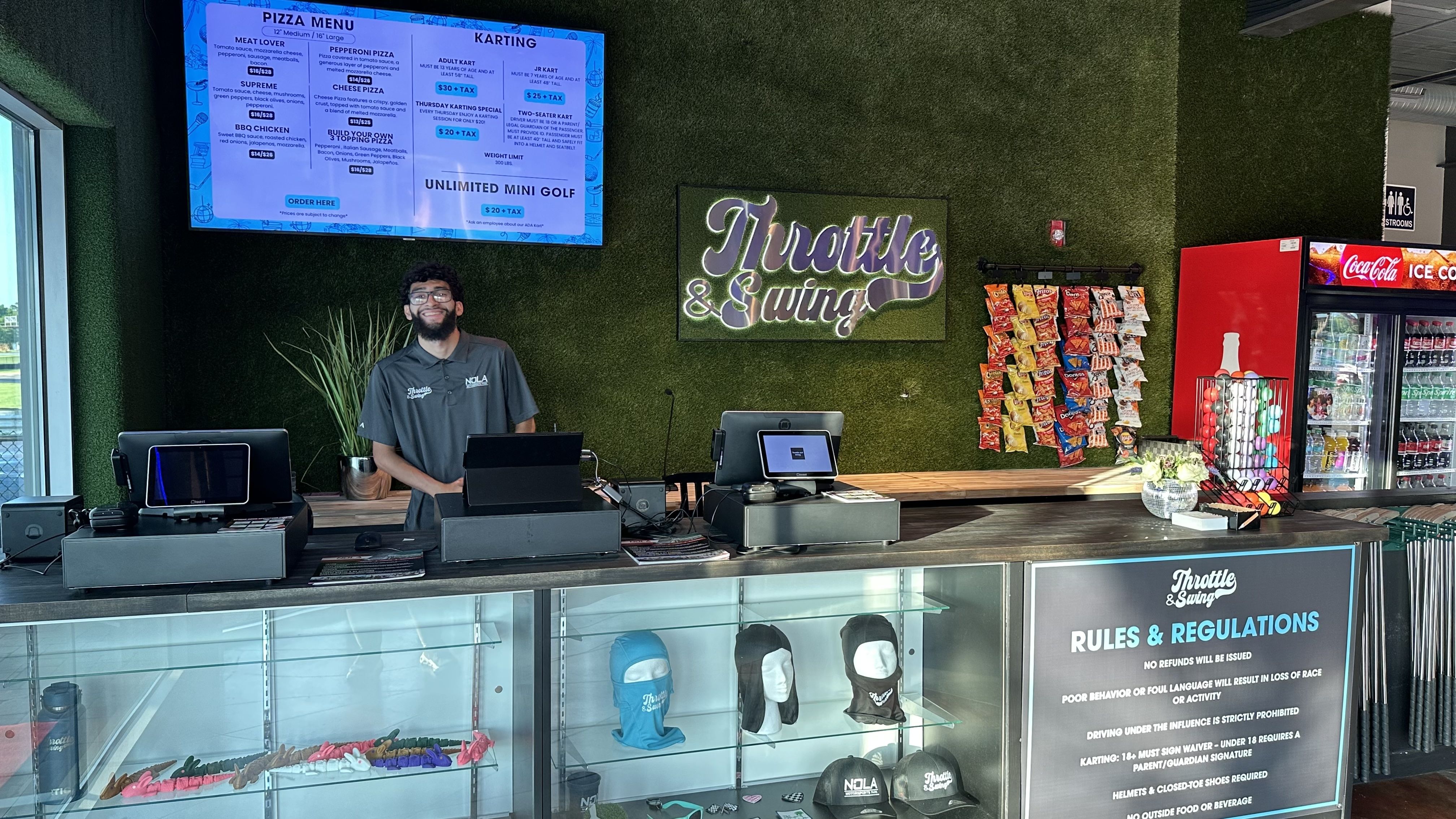 image show a man standing behind a front desk