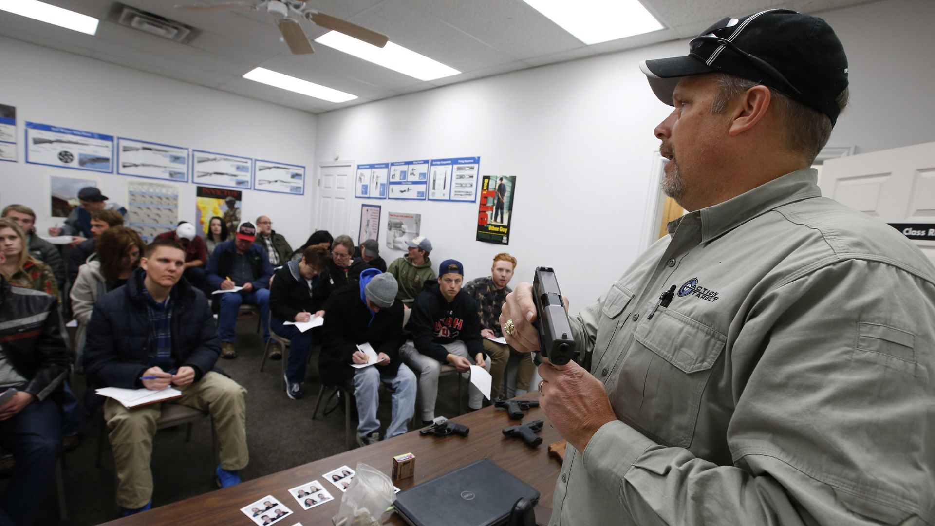 Gun instructor Mike Stilwell, demonstrates an semi automatic hand gun as as he teaches a packed class in Utah.