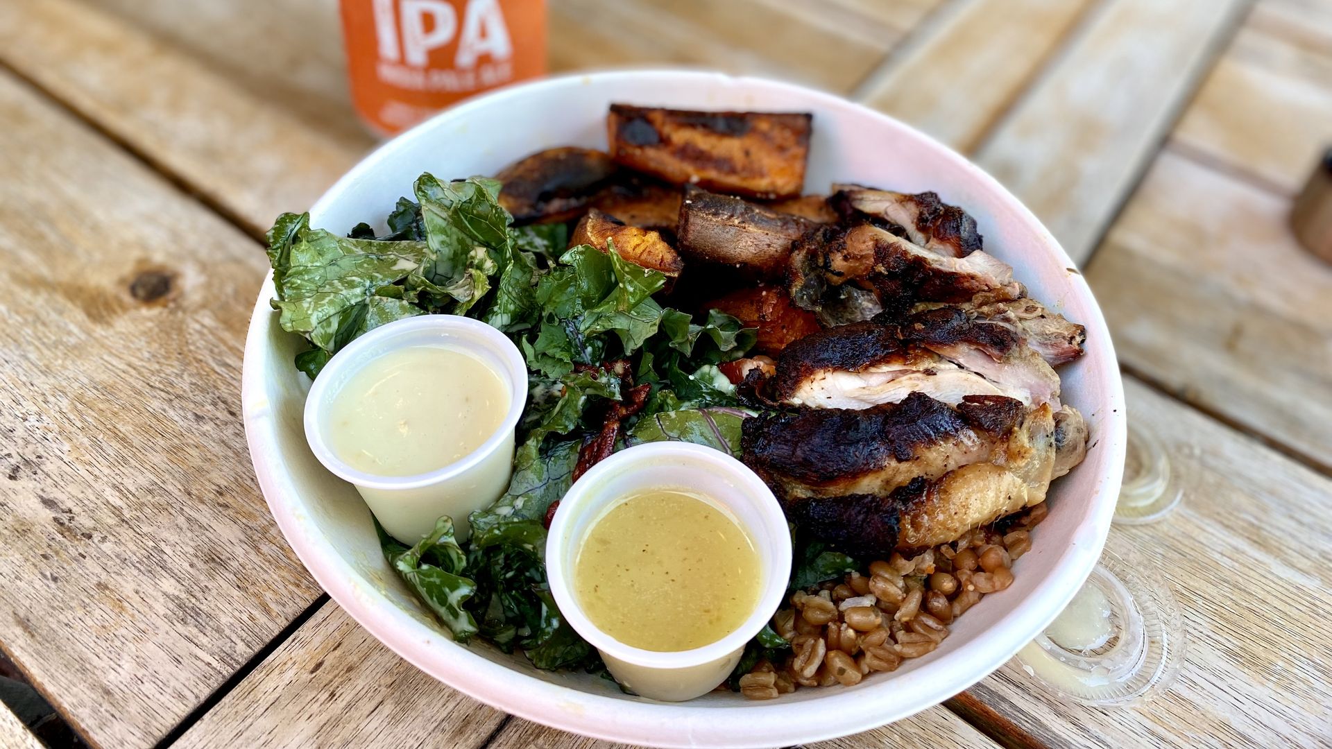 a photo of a bowl containing chicken, sweet potatoes, and lettuce