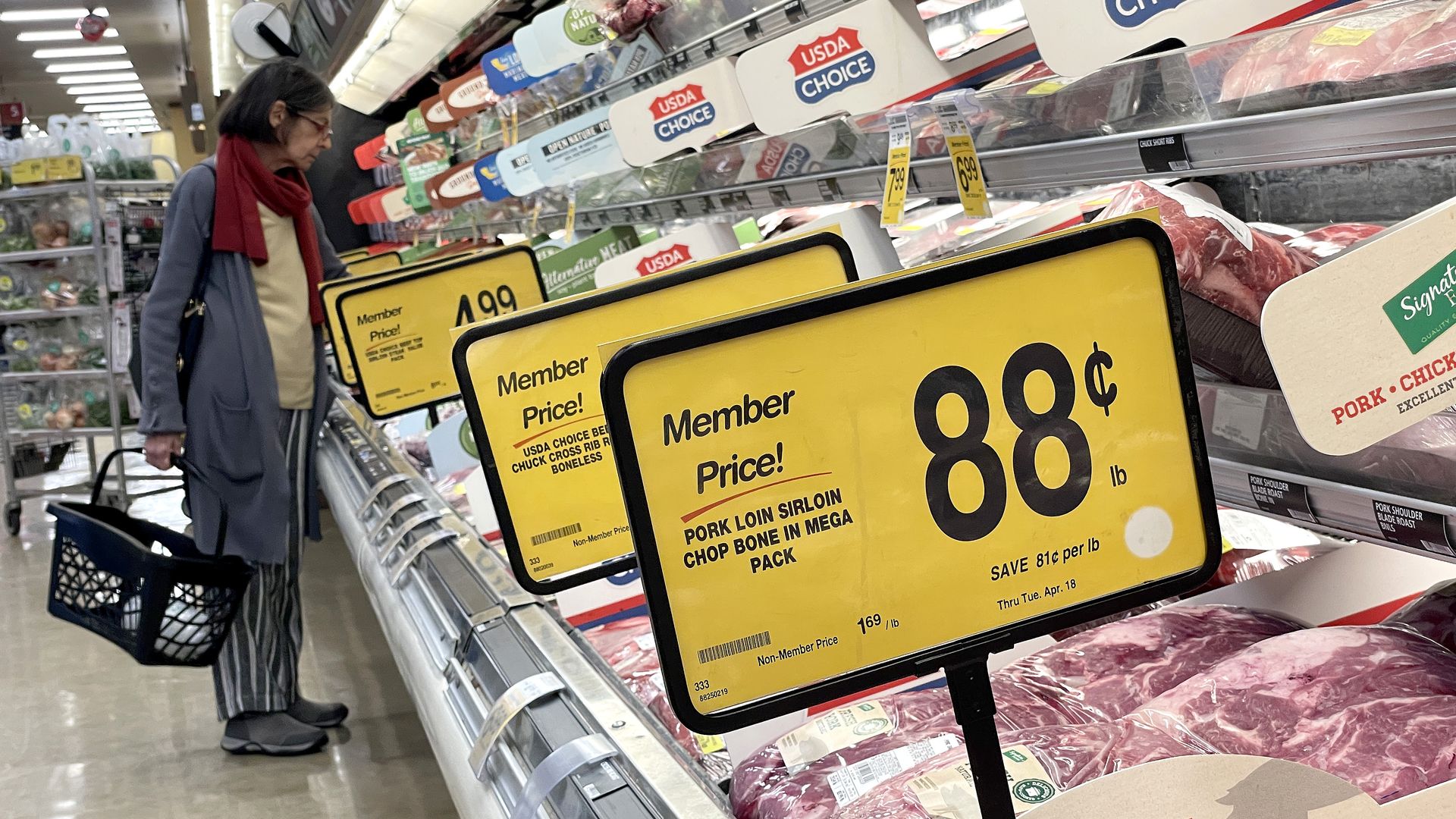 Woman stands at meet counter at a supermarket