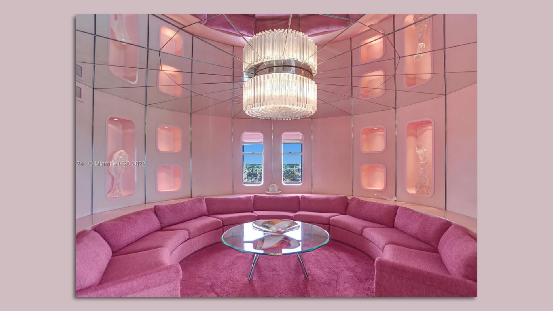 A pink rotunda wrapped in mirrors, with pink couches and carpeting.
