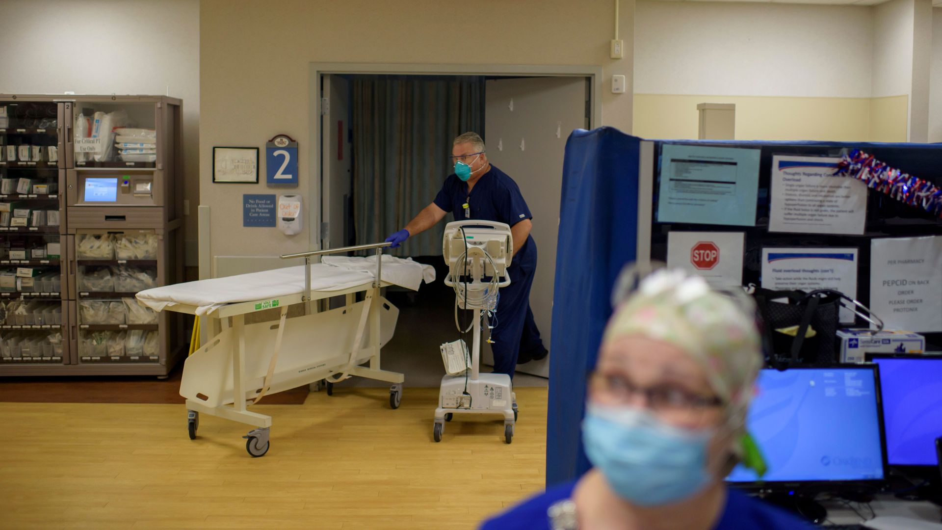 A healthcare worker wheels in a stretcher at a hospital