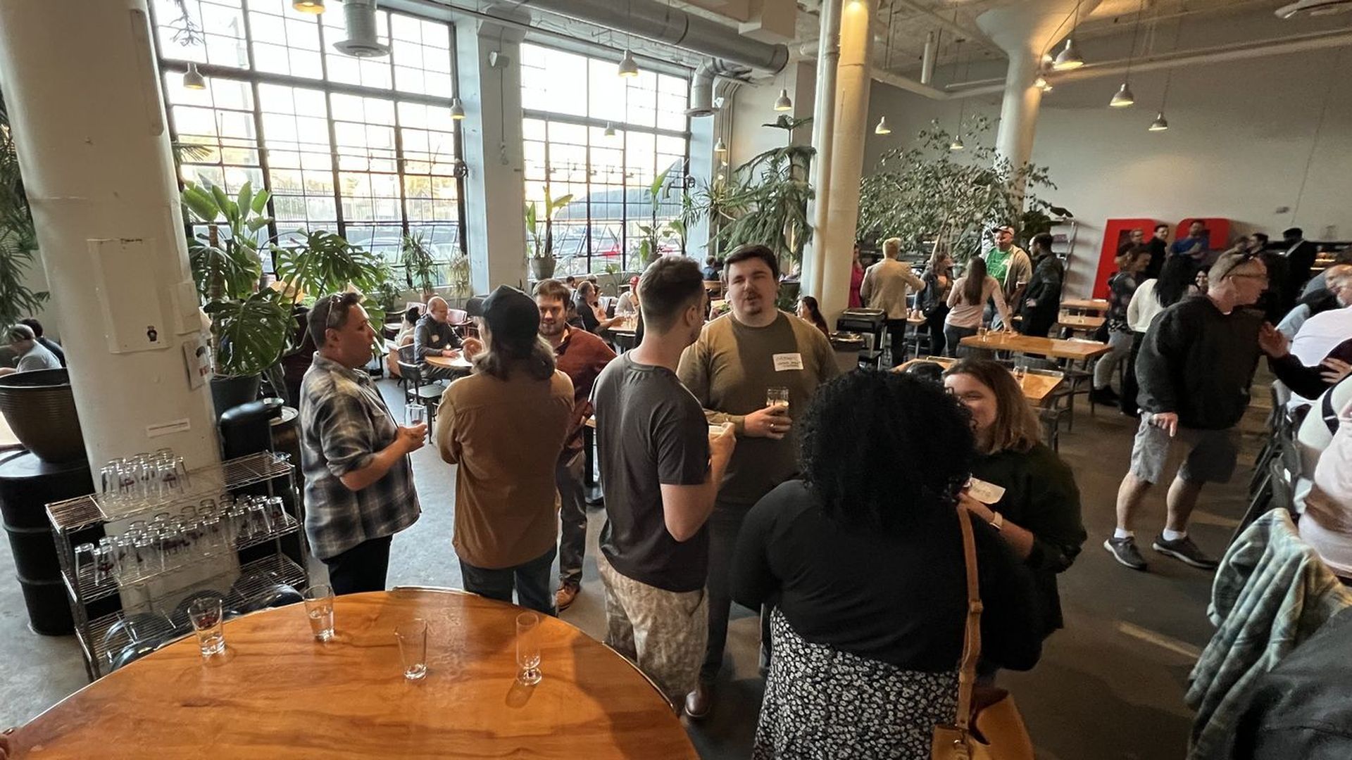 A group of people at a brewery stand around talking