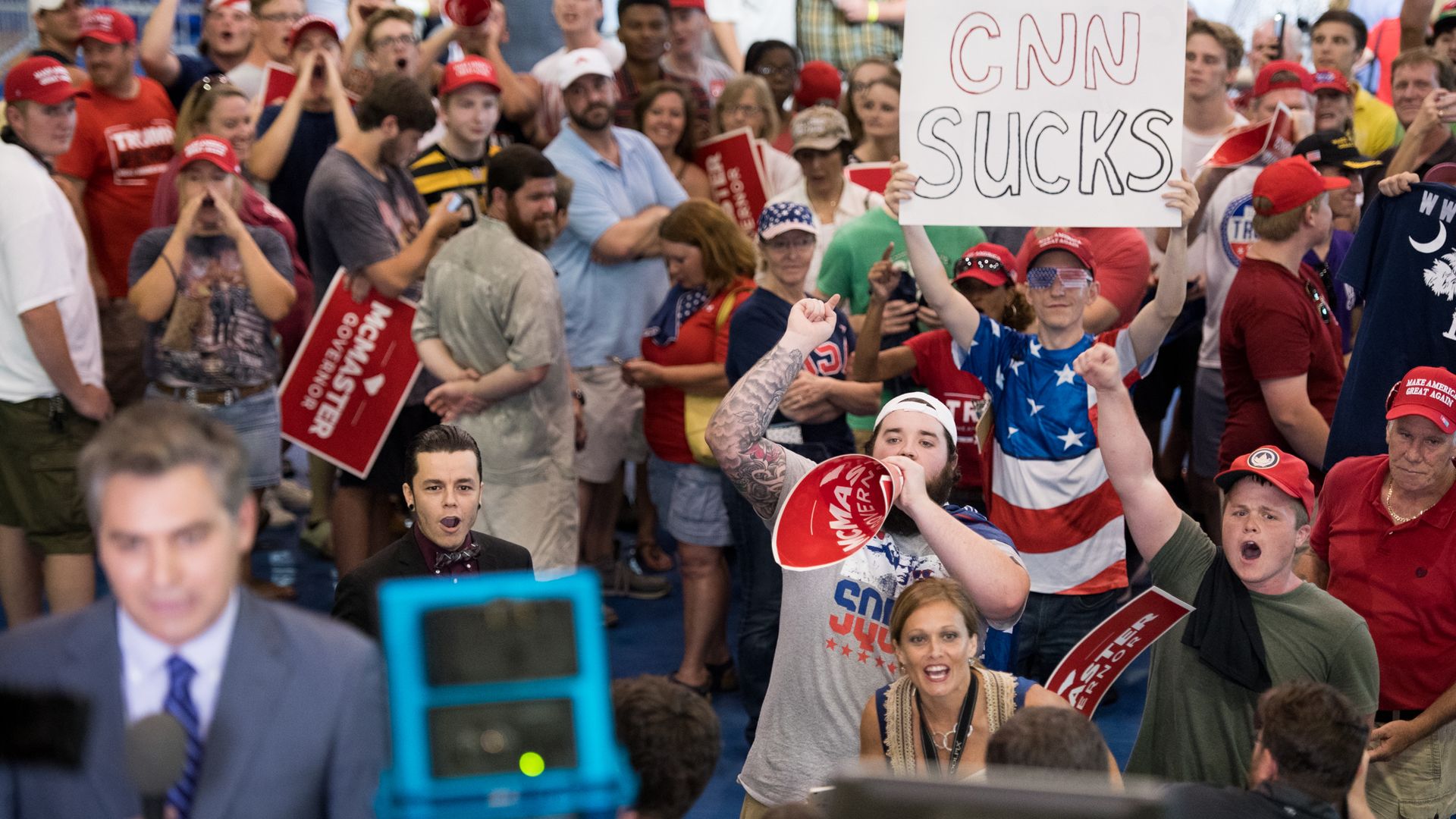 A group of people at a Trump rally shout at CNN reporter Jim Acosta. 