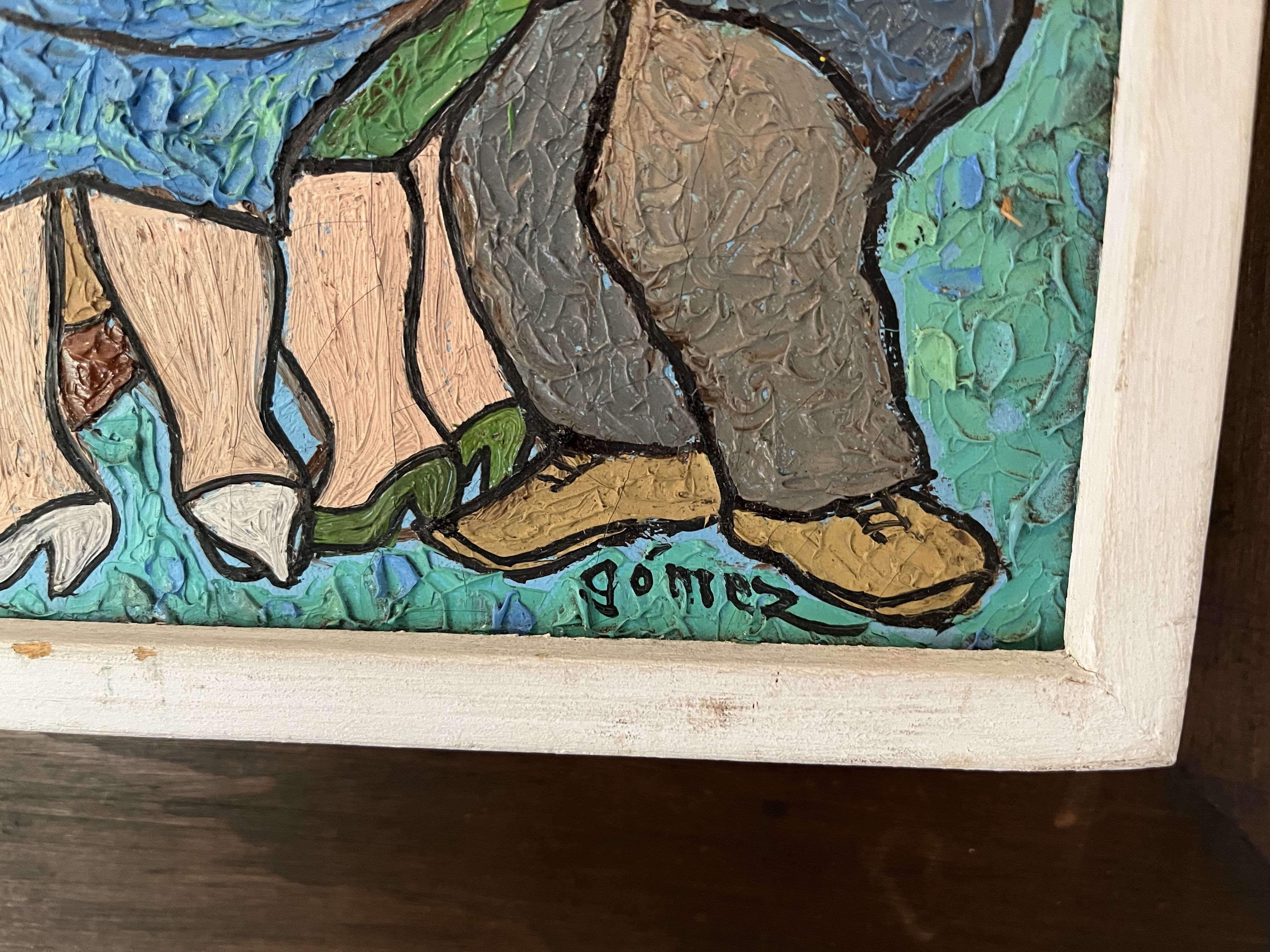 Close-up of a thickly textured painting with blue, green, brown, and beige swaths; bold black outlines define abstract shapes. A light wooden frame surrounds the artwork.