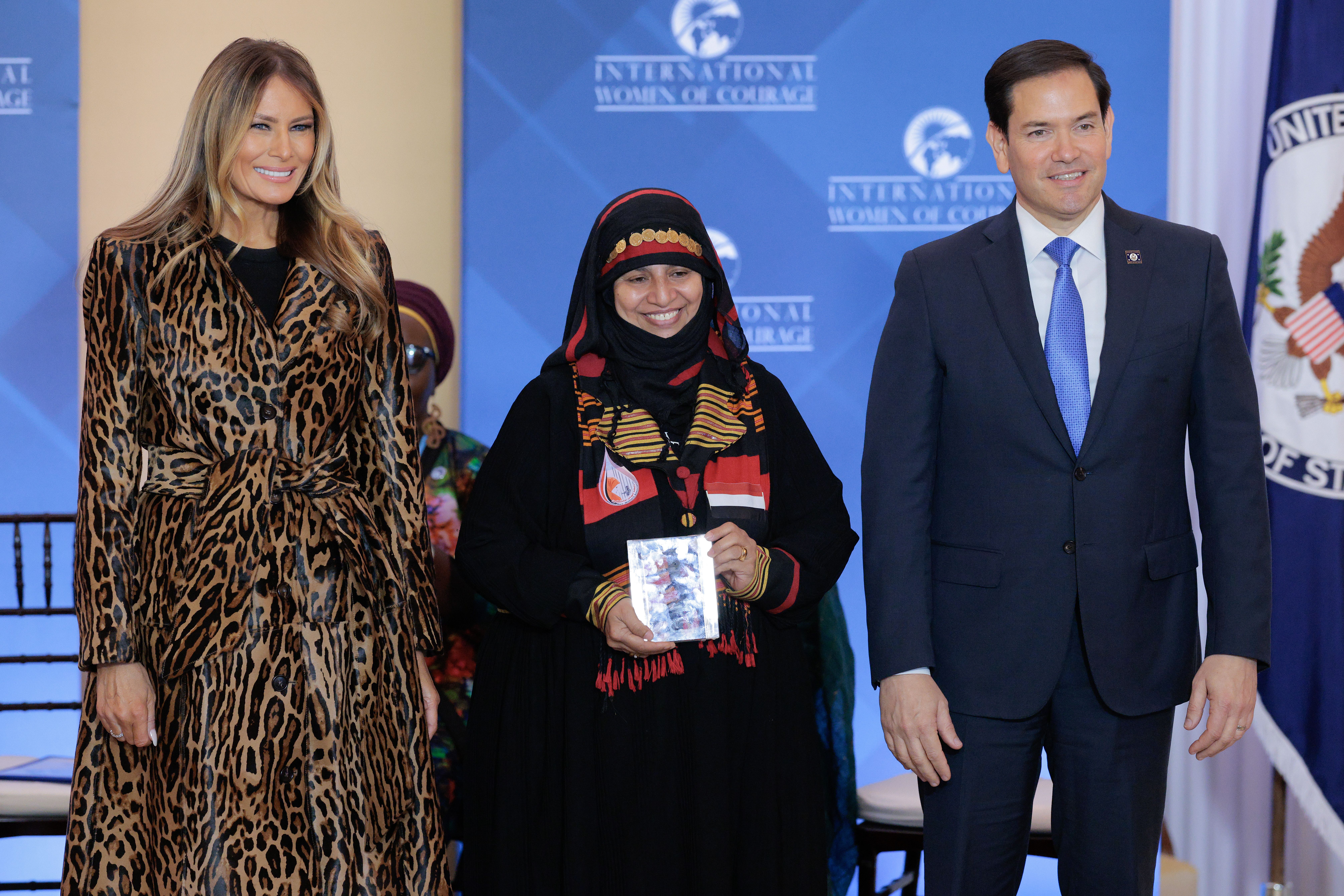 First lady Melania Trump (L) and Secretary of State Marco Rubio pose with International Women of Courage Award recipient Amat Al-Salam Al-Hajj of Yemen during a ceremony in the Ben Franklin Room at the State Department's Harry S. Truman headquarters on April 01, 2025 in Washington, DC. 