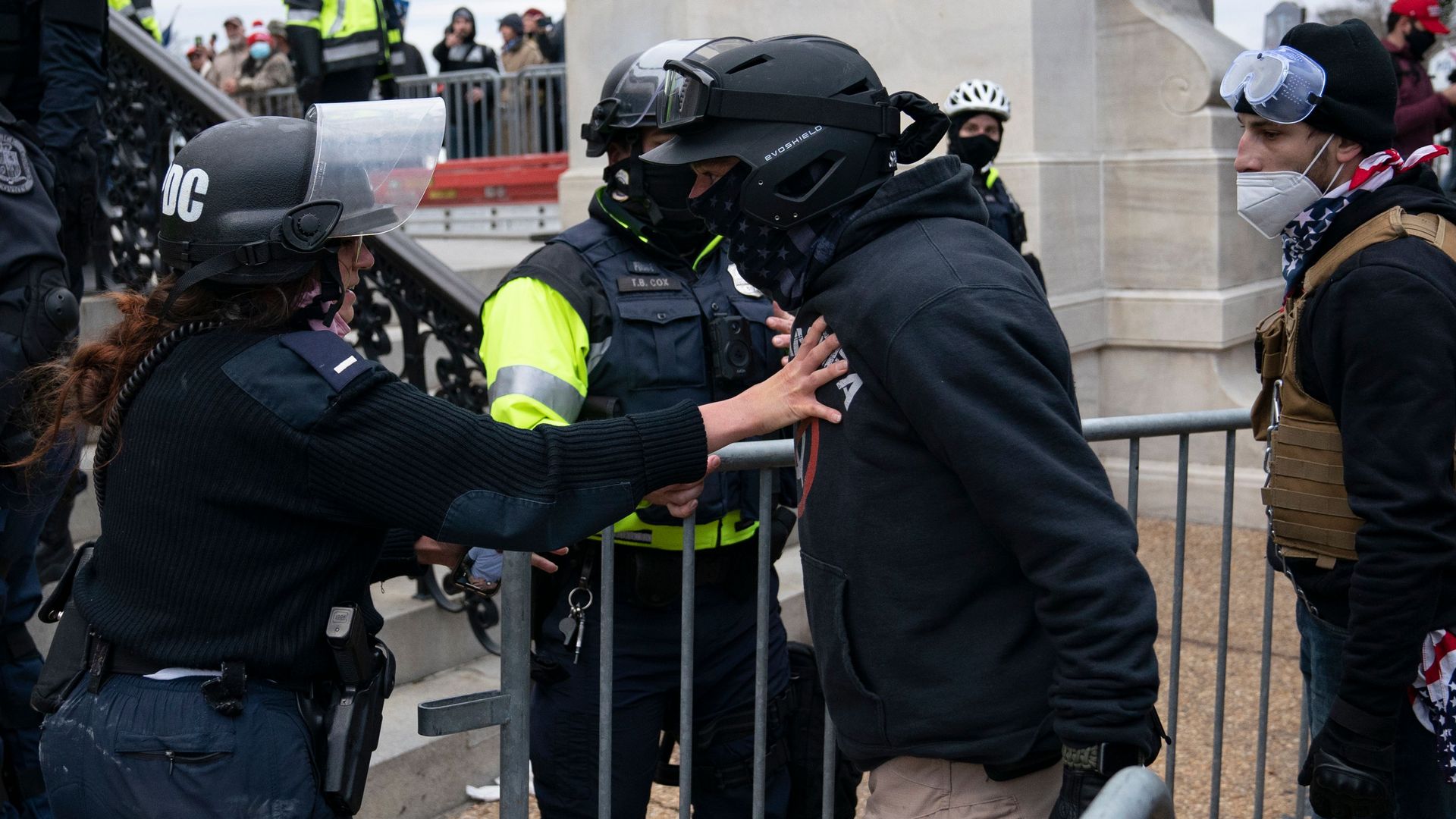 A protester, who claims to be a member of the Proud Boys, confronts police officers as supporters of US President Donald Trump protest outside the US Capitol on January 6, 2021,