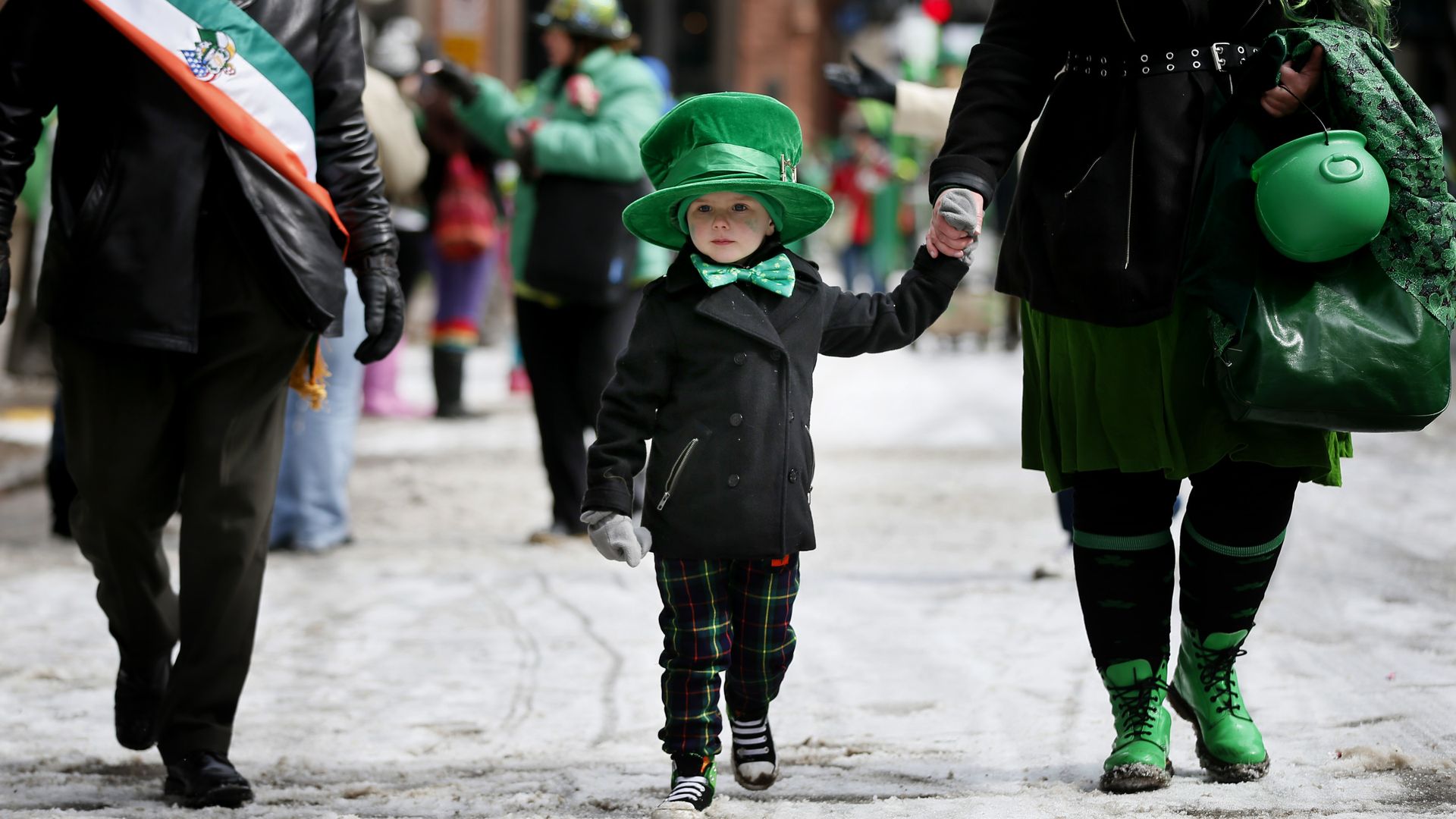 A boy with a green hat walks through downtown St. Paul on St. Patrick's Day 2014