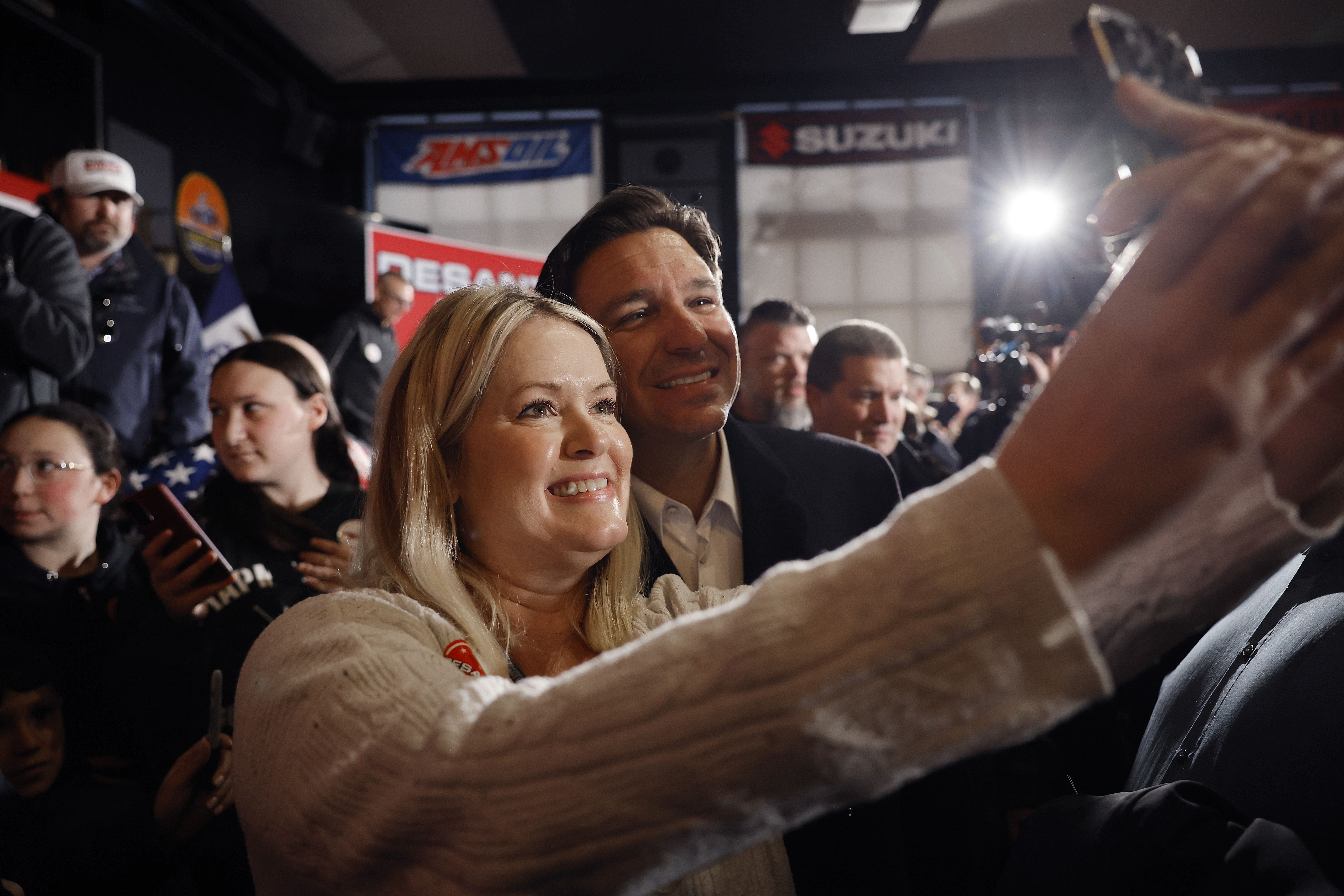  Republican presidential candidate Florida Gov. Ron DeSantis poses for photographs with people during a campaign event at the Chrome Horse Saloon one day before the Iowa caucuses on January 14, 2024 in Cedar Rapids, Iowa. DeSantis and fellow Republican presidential candidates have been adjusting their campaign schedules to deal with blizzard-like conditions in Iowa a day before the caucuses, the first primary competition of the 2024 election year. 