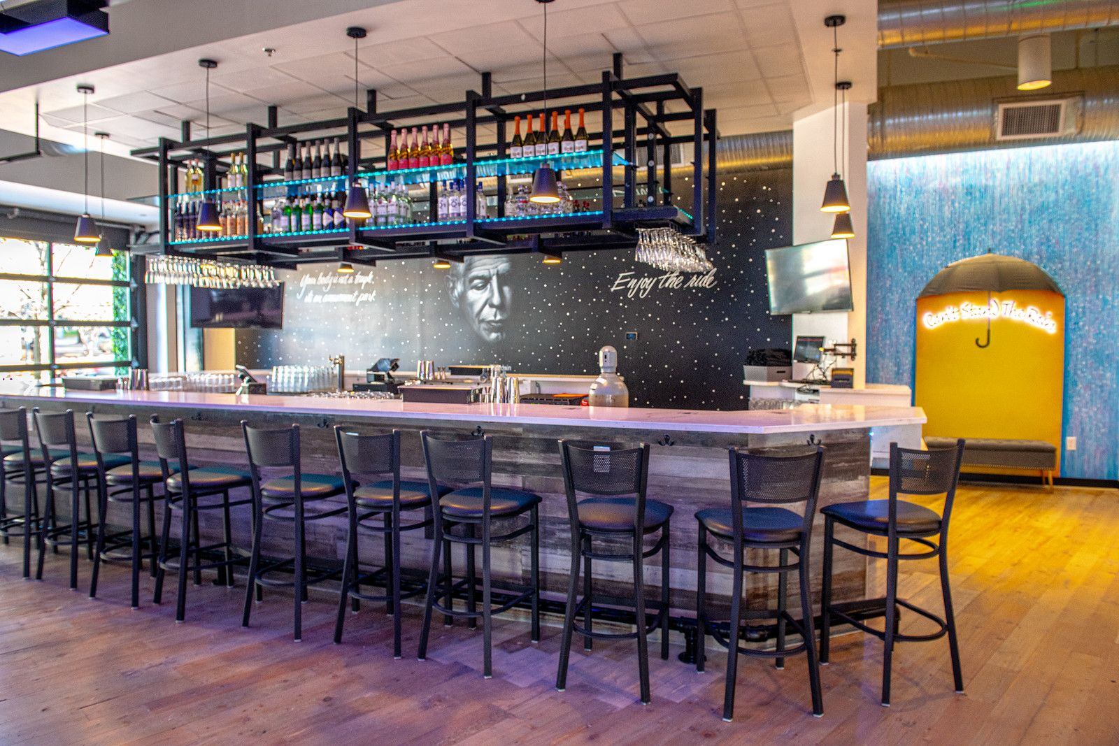 A bar with a mural of Anthony Bourdain in the background