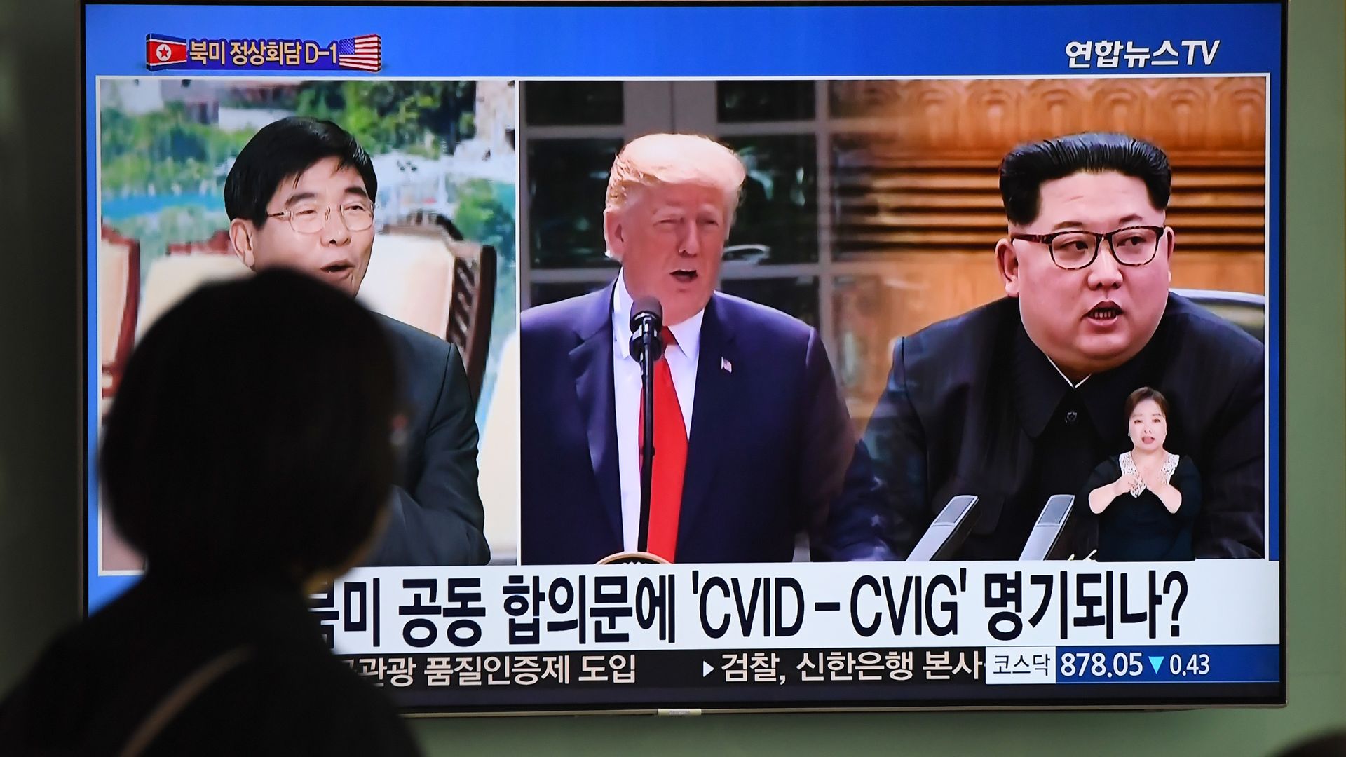 A television news screen showing President Donald Trump and North Korean leader Kim Jong at a train station in Seoul. 