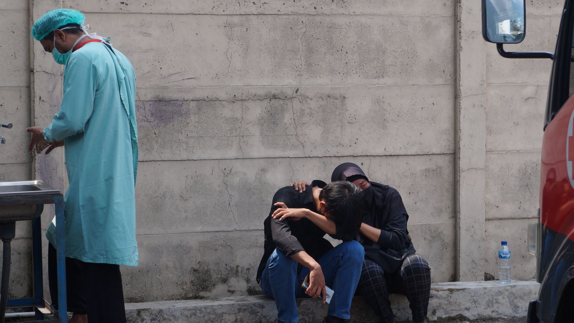 The family of one of a fire victims mourns while sitting in front of the prison in Tangerang on September 8