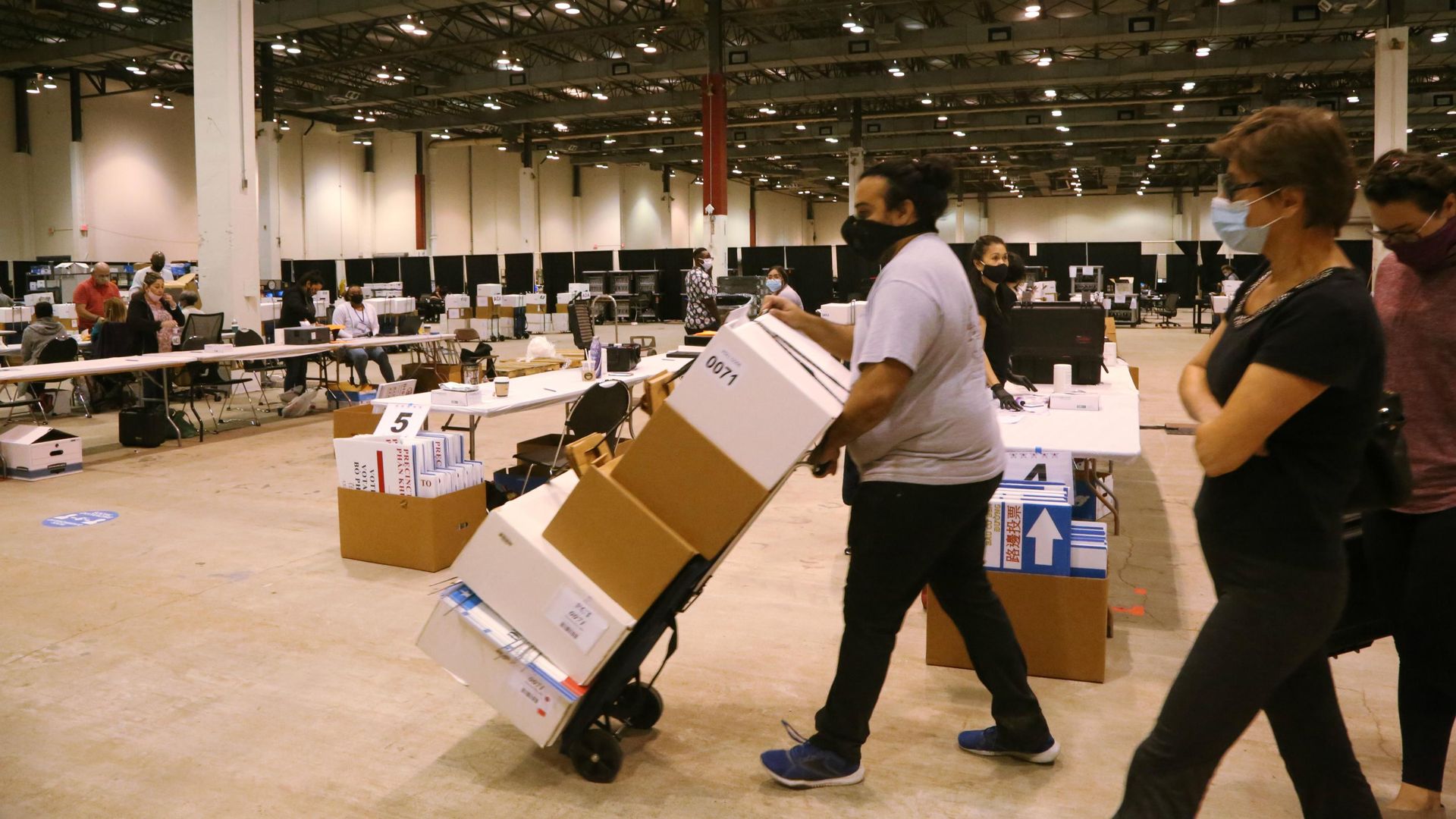 People carry boxes of ballots