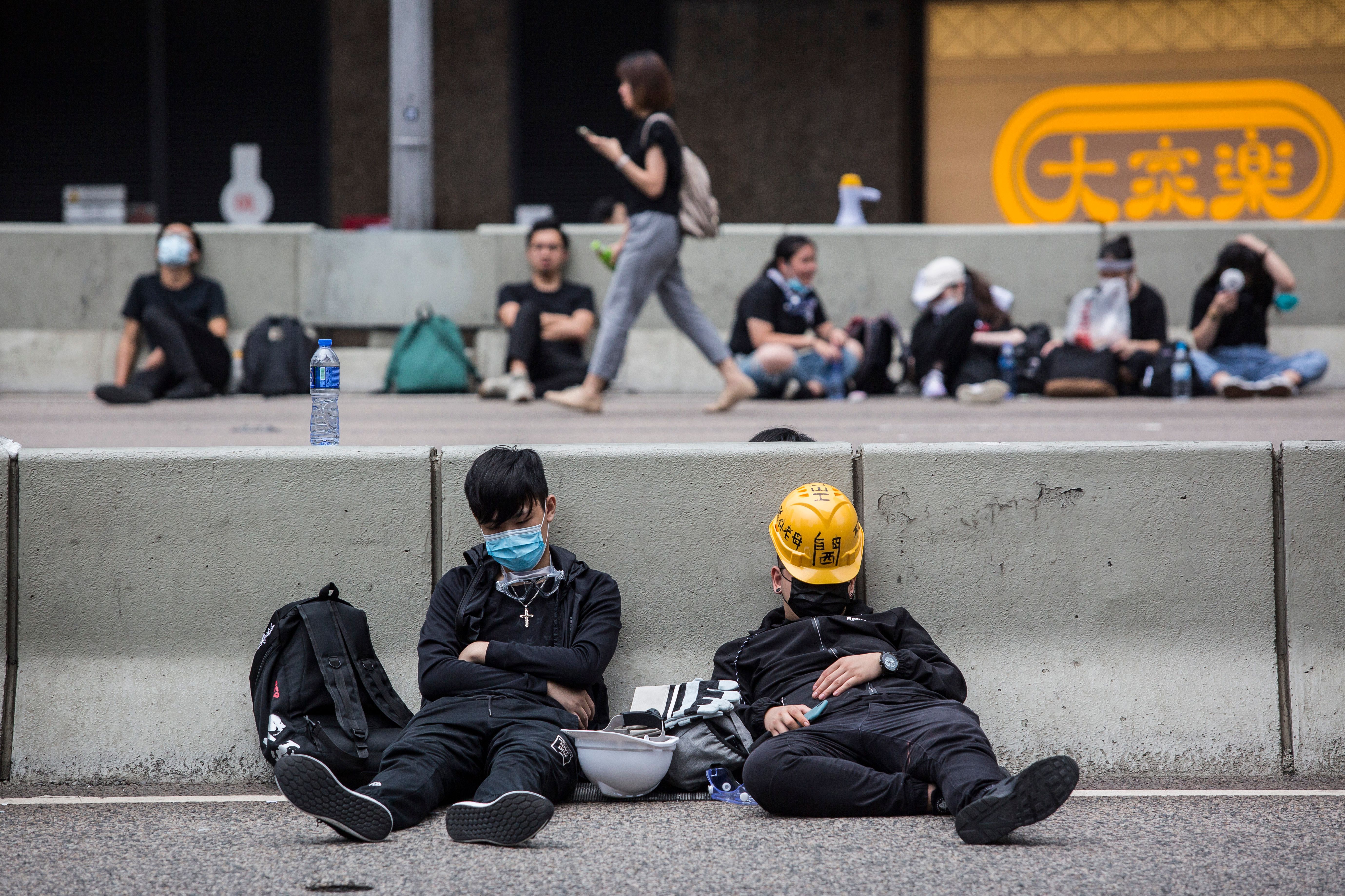 Protesters sleep on a road as they rally against a controversial extradition bill in Hong Kong early on June 17, 2019.