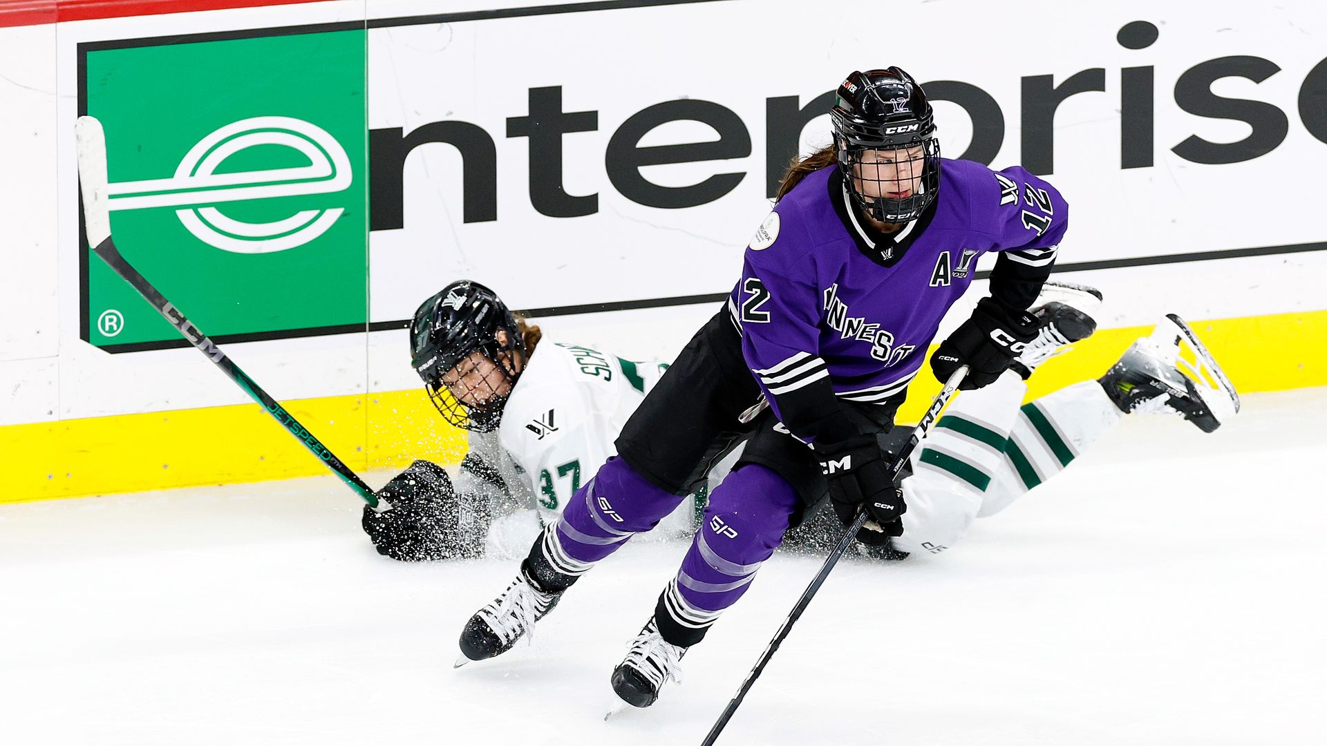 Kelly Pannek #12 of Minnesota skates with the puck past Theresa Schafzahl #37 of Boston during the s